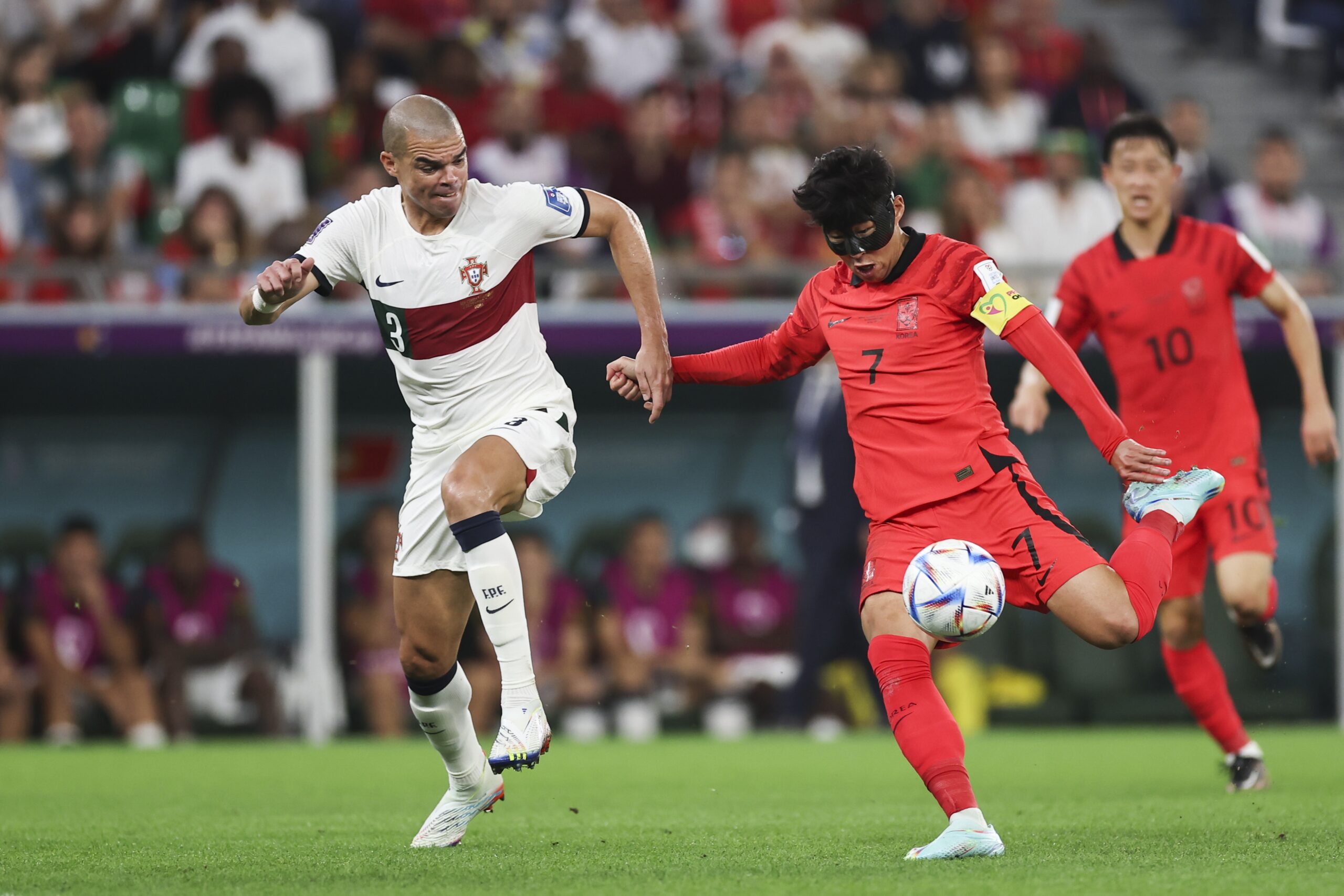 epa10344647 Heungmin Son (R) of South Korea in action against Pepe of Portugal during the FIFA World Cup 2022 group H soccer match between South Korea and Portugal at Education City Stadium in Doha, Qatar, 02 December 2022.  EPA-EFE/JOSE SENA GOULAO