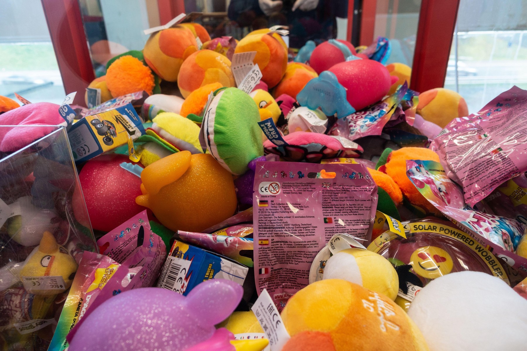 A claw or crane game full of enticing colourful stuffed toys.