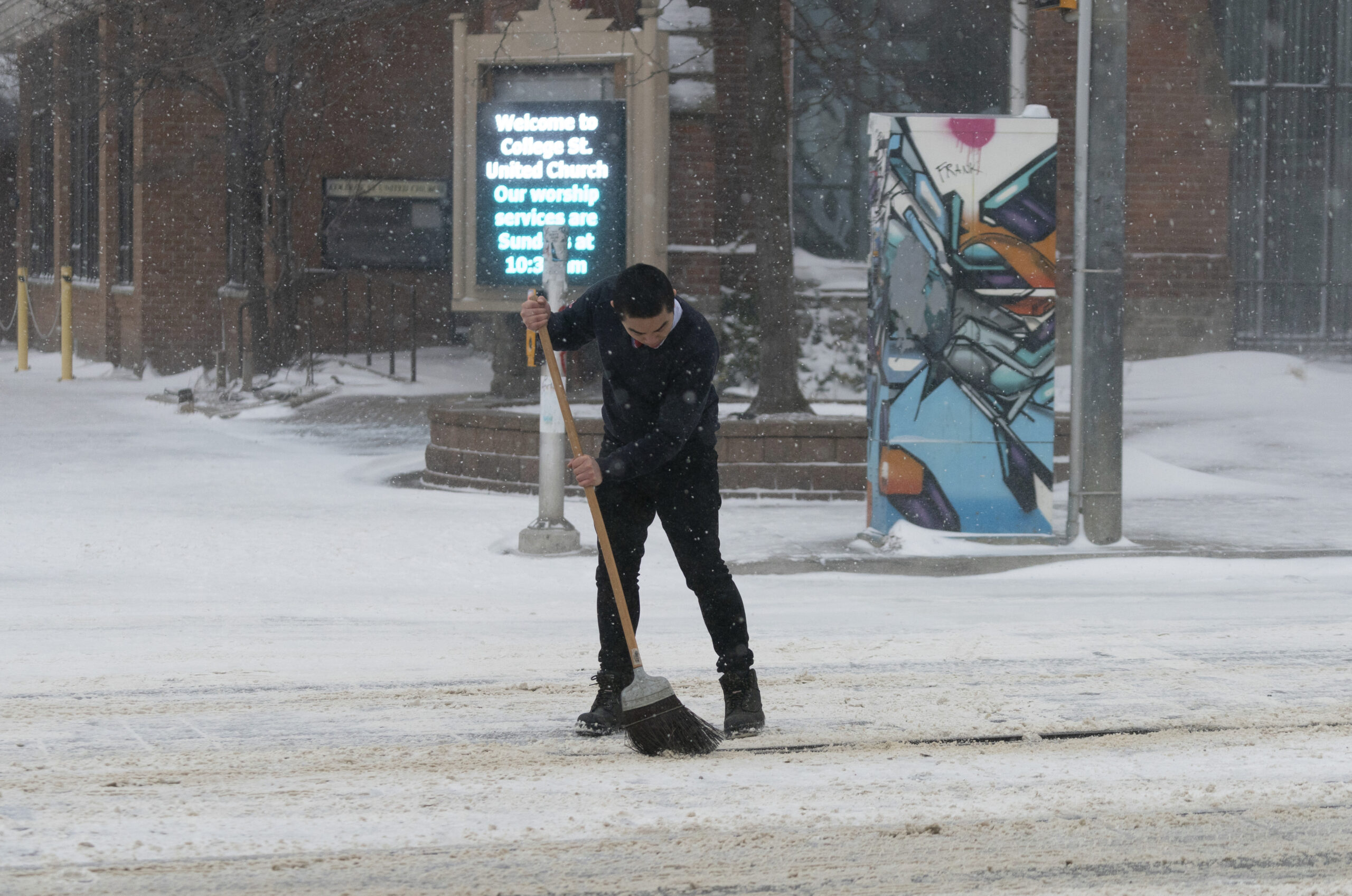A streetcar driver attempts to sweep snow off of the tracks during a snowstorm in Toronto on Friday, Dec. 23, 2022. A winter storm warning is in place for most of southern Ontario. (Arlyn McAdorey/The Canadian Press via AP)