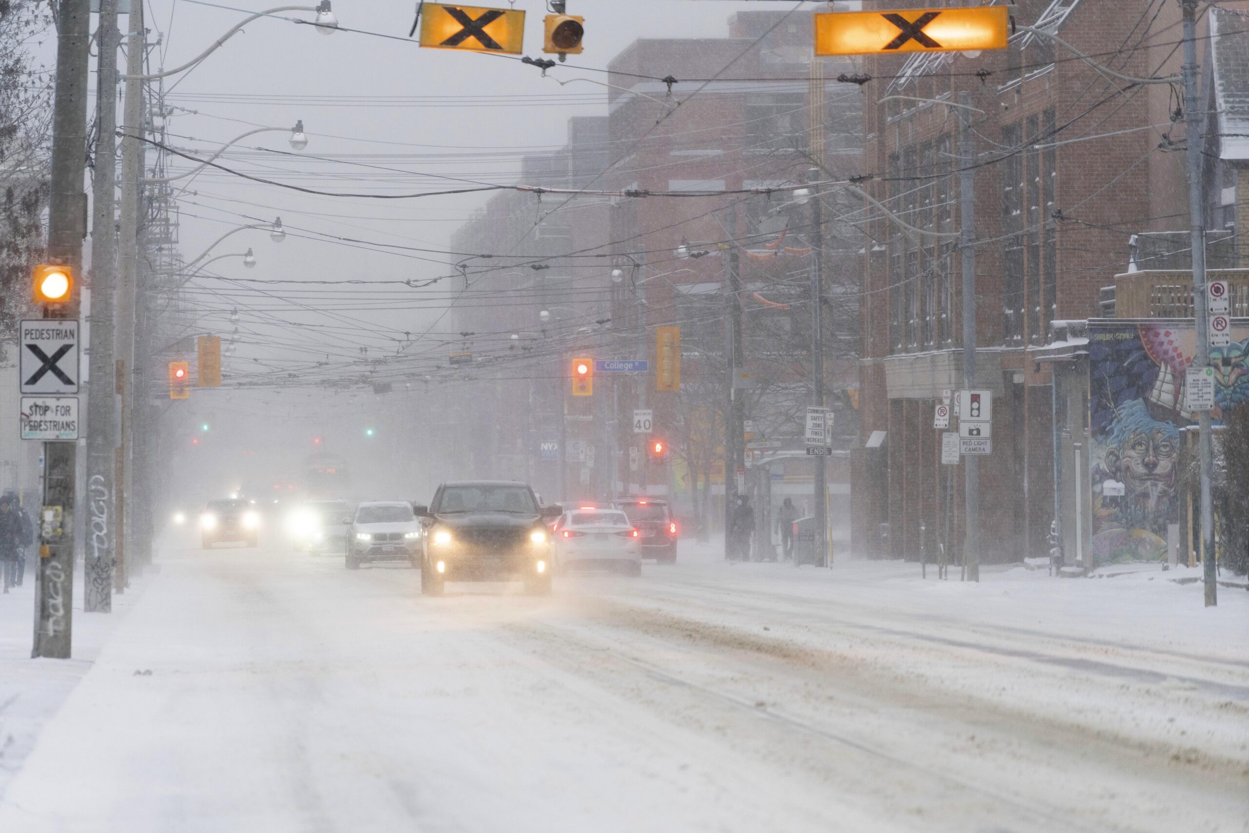 Cars drive through blowing snow during a snowstorm in Toronto on Friday, Dec., 23, 2022. A winter storm warning is in place for most of southern Ontario. (Arlyn McAdorey/The Canadian Press via AP)