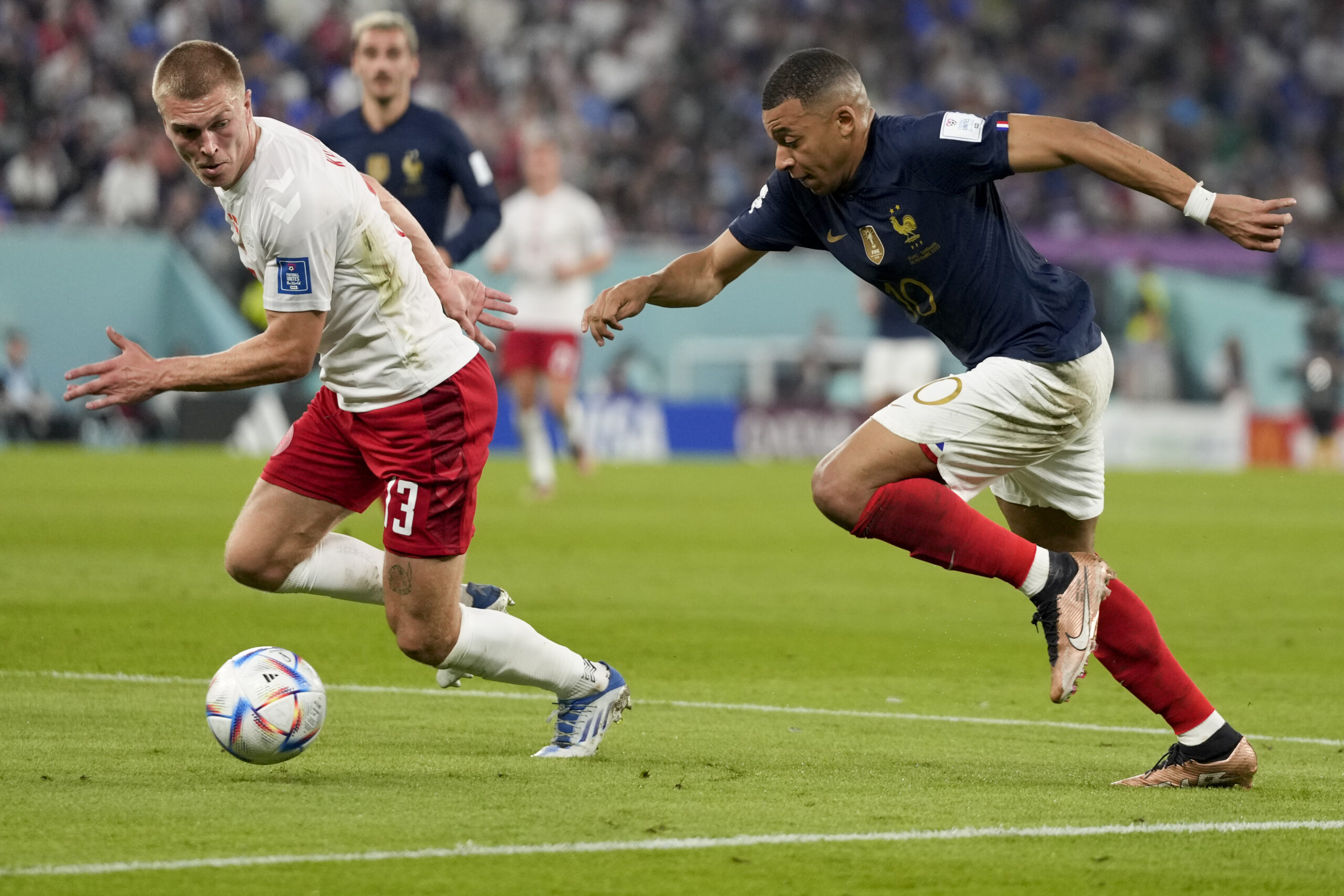 France's Kylian Mbappe, right, and Denmark's Rasmus Kristensen battle for the ball during the World Cup group D soccer match between France and Denmark, at the Stadium 974 in Doha, Qatar, Saturday, Nov. 26, 2022. (AP Photo/Frank Augstein)