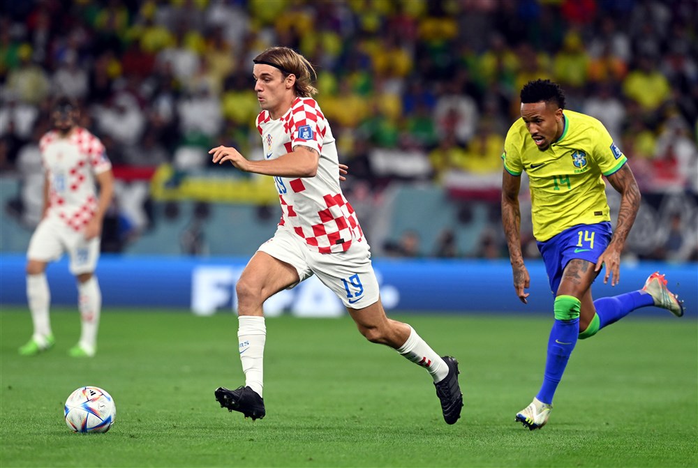 epa10356900 Borna Sosa (L) of Croatia in action against Eder Militao of Brazil during the FIFA World Cup 2022 quarter final soccer match between Croatia and Brazil at Education City Stadium in Doha, Qatar, 09 December 2022.  EPA-EFE/Neil Hall