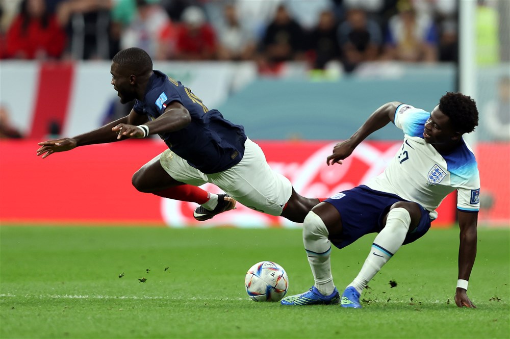 epa10360093 Bukayo Saka (R) of England in action against Dayot Upamecano of France during the FIFA World Cup 2022 quarter final soccer match between England and France at Al Bayt Stadium in Al Khor, Qatar, 10 December 2022.  EPA-EFE/Tolga Bozoglu