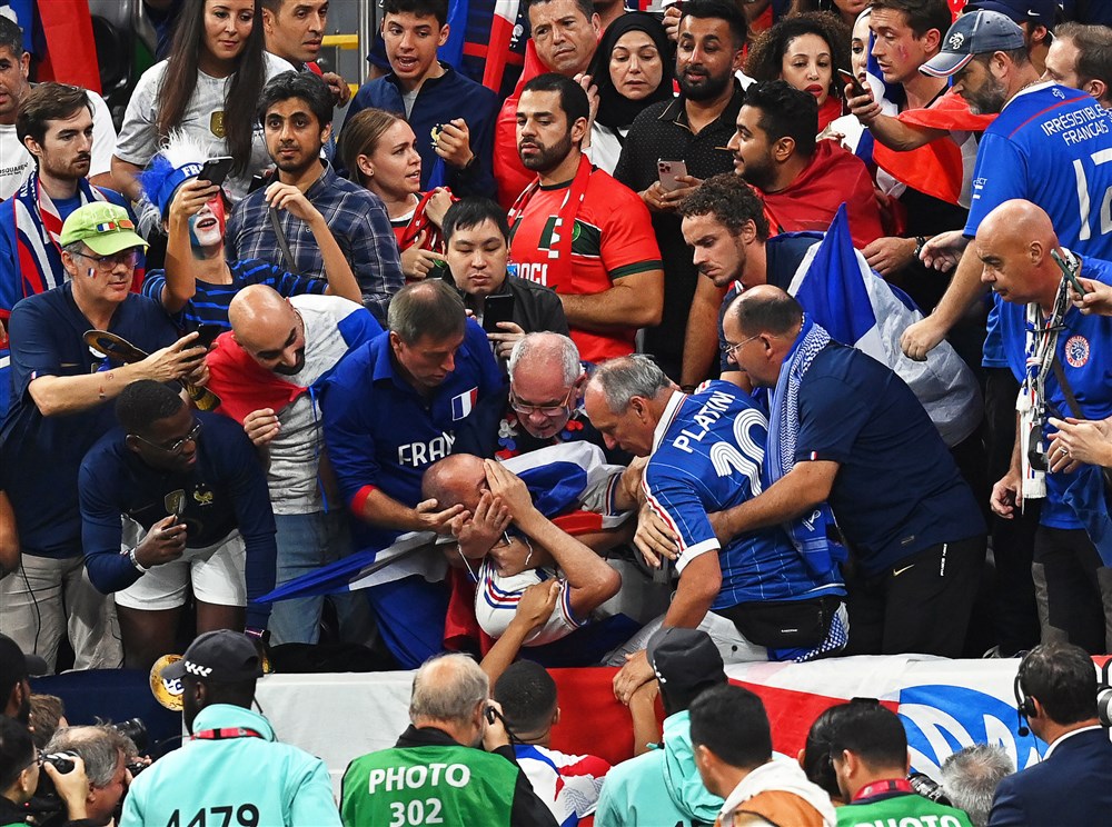 epa10365788 A fan of France (C) reacts after being hit by a ball prior to the FIFA World Cup 2022 semi final between France and Morocco at Al Bayt Stadium in Al Khor, Qatar, 14 December 2022.  EPA-EFE/Georgi Licovski