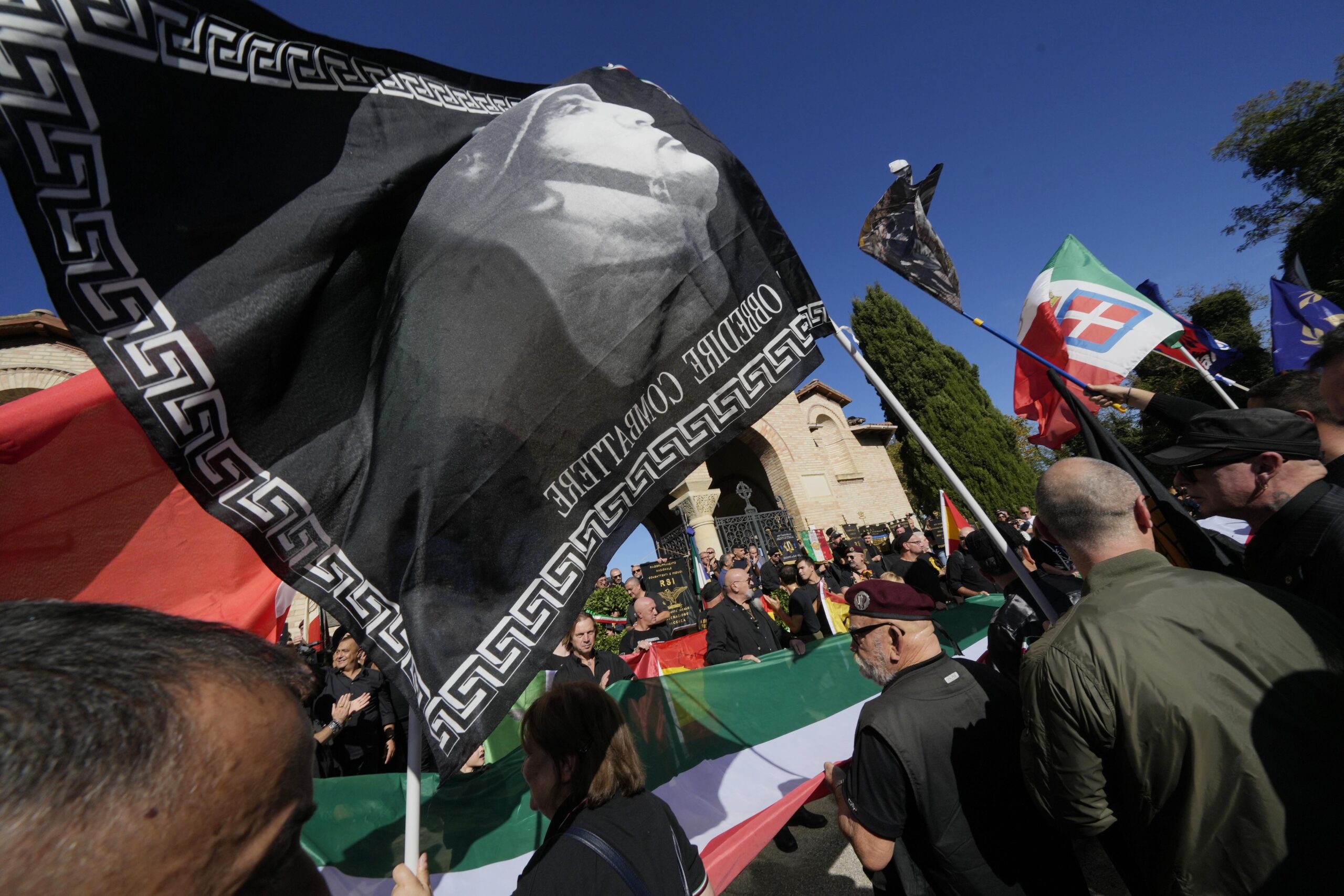 People march in the hometown of former dictator Benito Mussolini to mark the 100th anniversary of the coup d'etat by which he sized power in 1922, in Predappio, Italy, Sunday, Oct. 30, 2022. (AP Photo/Luca Bruno)