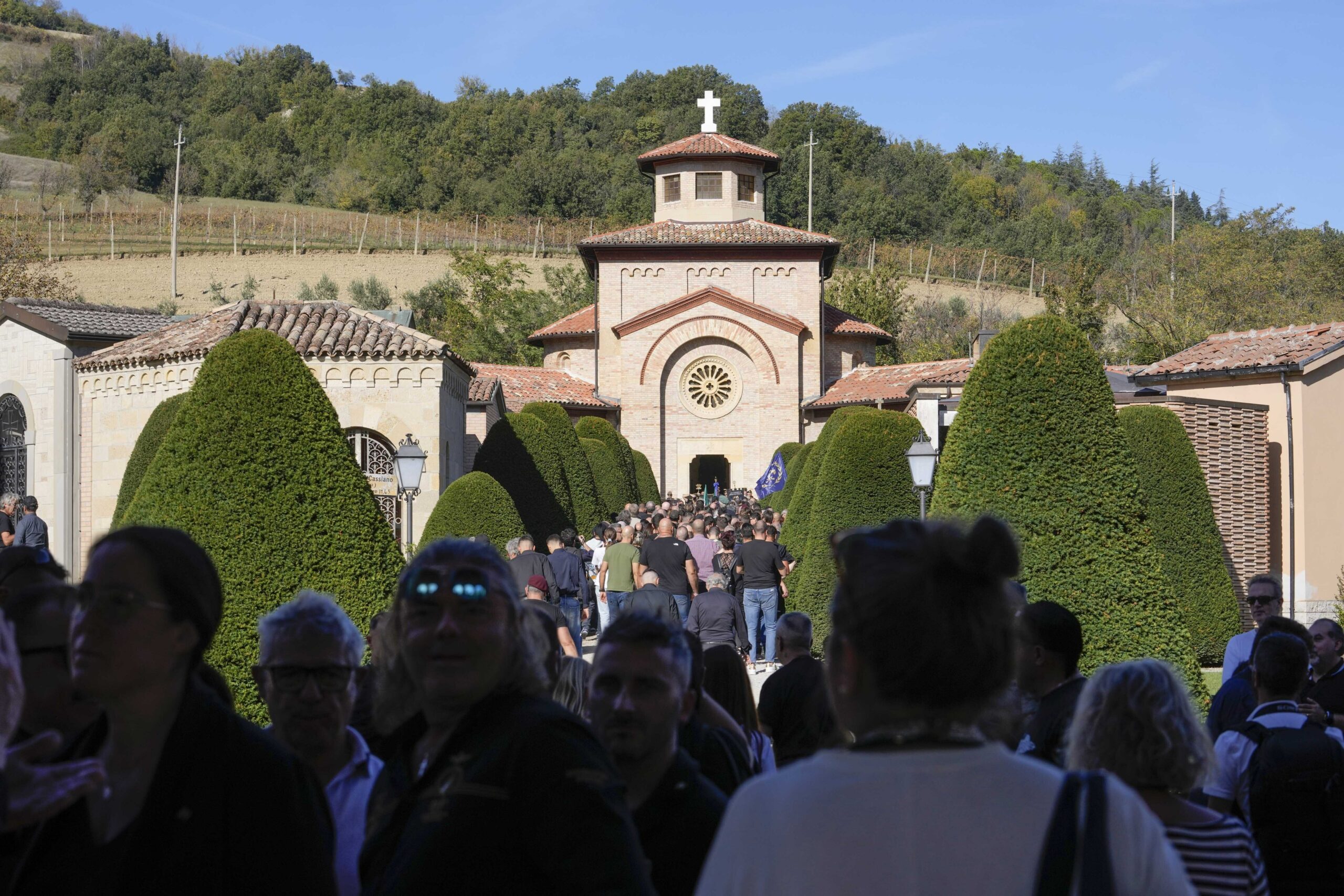 People queue to visit the crypt of former dictator Benito Mussolini at the San Cassiano cemetery, to mark the 100th anniversary of the coup d'etat by which he sized power in 1922, in Predappio, Italy, Sunday, Oct. 30, 2022. (AP Photo/Luca Bruno)