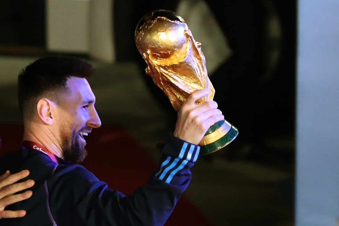 epa10374439 Lionel Messi of the Argentina national soccer team holds the trophy of Qatar 2022 World Cup upon the team's arrival to the International Airport of Ezeiza, some 22km of Buenos Aires, Argentina, 20 December 2022.  EPA-EFE/RAUL MARTINEZ