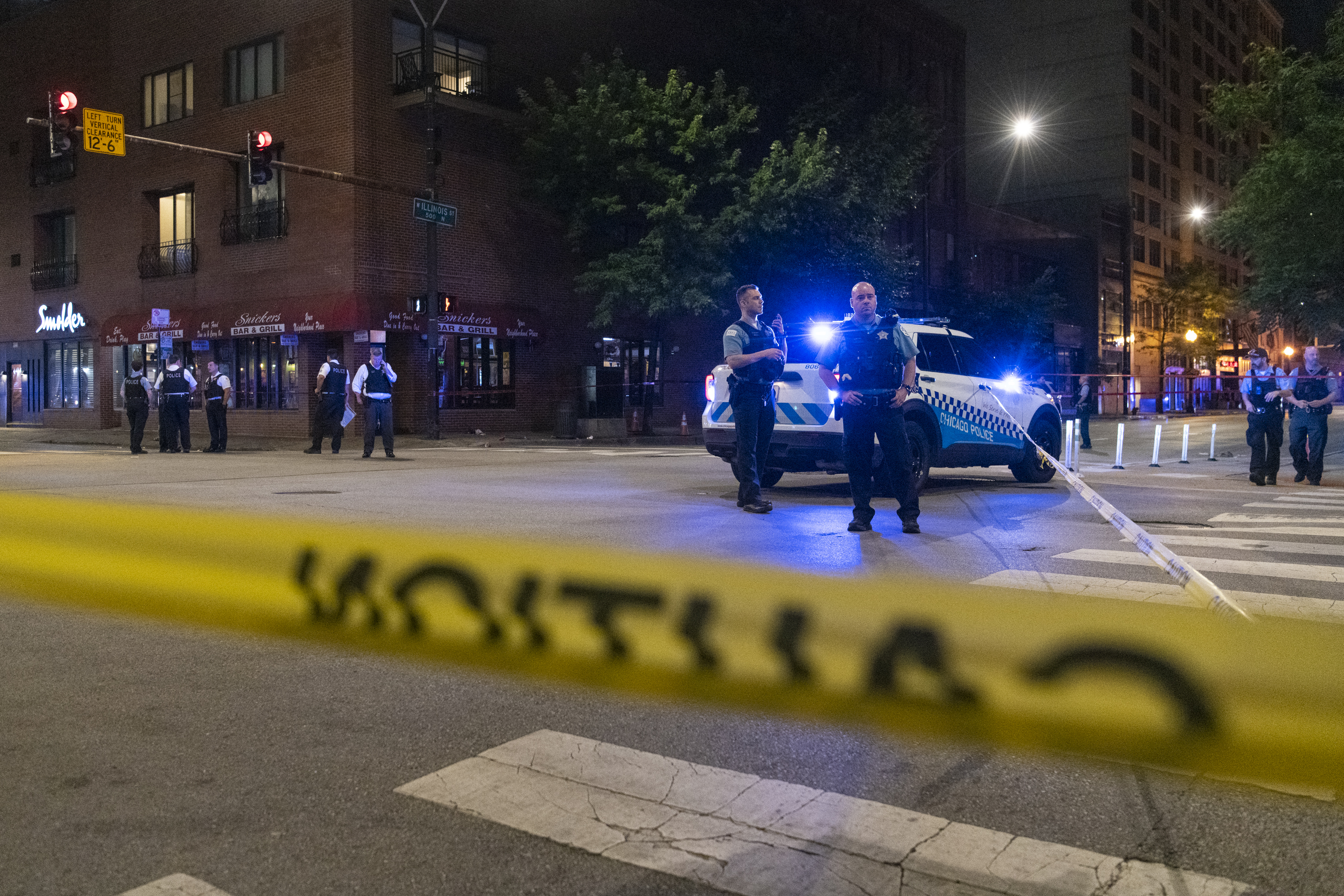 Chicago police work the scene of a shooting outside Snickers Bar &amp; Grill, in the River North neighborhood, Sunday, July 10, 2022. (Tyler Pasciak LaRiviere/Chicago Sun-Times via AP)