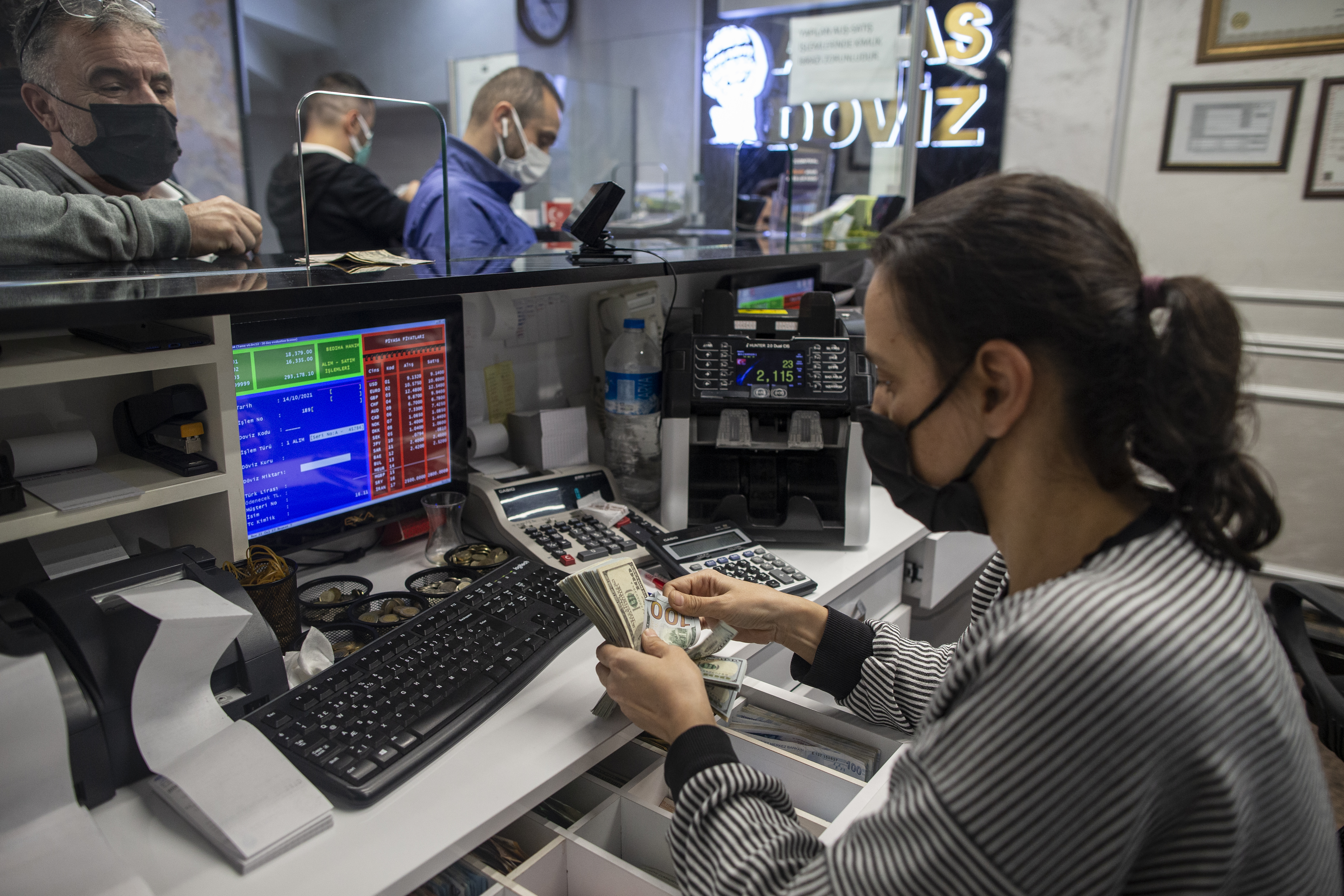 epa09523698 People exchange their money at an exchange office in Istanbul, Turkey, 14 October 2021. Turkish lira hits a record low of 9.19 liras to the US Dollar after the Turkish prestident sacked three central bank policymakers.  EPA-EFE/ERDEM SAHIN
