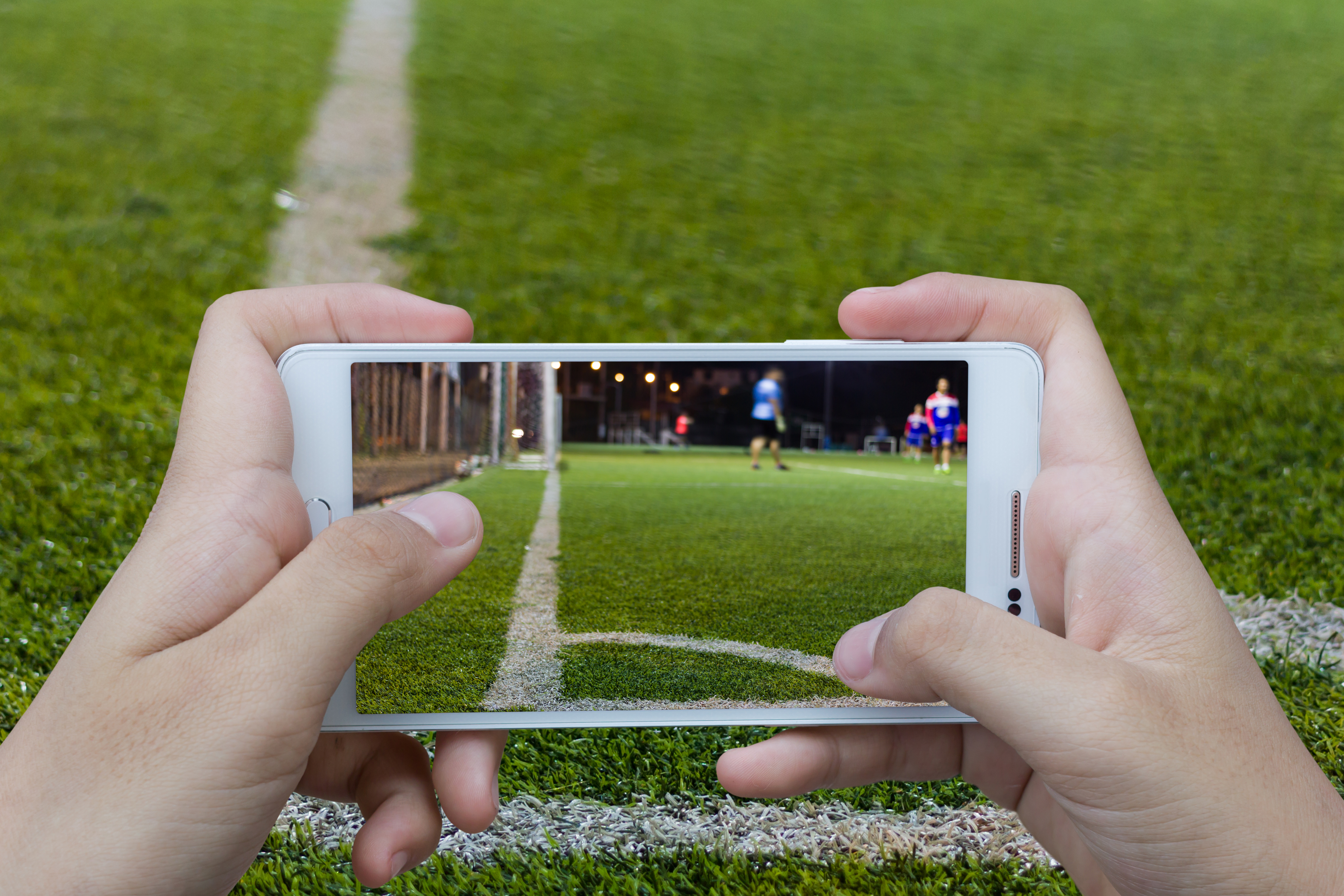 Man,Use,Mobile,Phone,,Blur,Image,Of,Soccer,Game,As