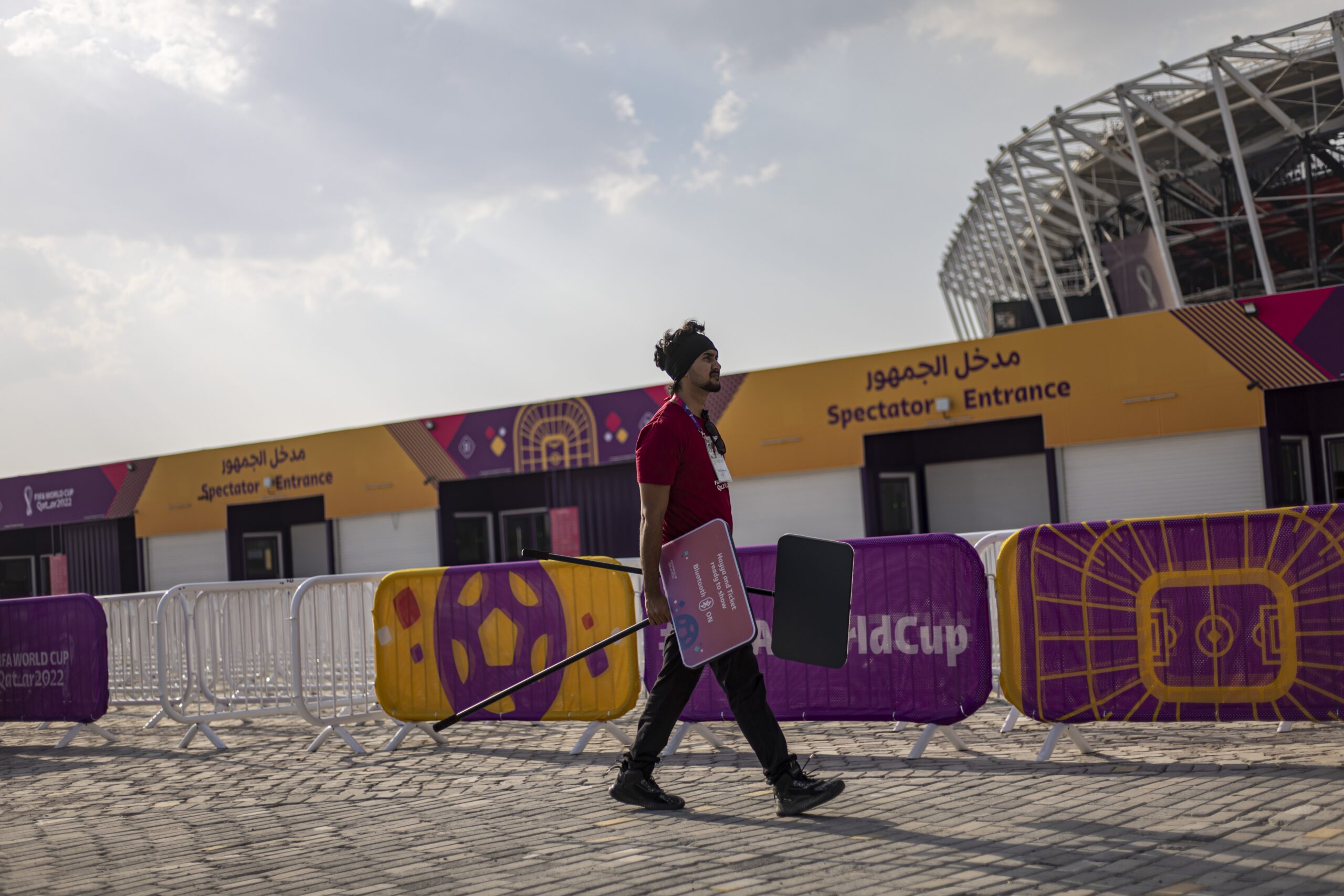 epa10313085 A worker carries signs outside 974 Stadium in Doha, Qatar, 18 November 2022. The FIFA World Cup Qatar 2022 will take place from 20 November to 18 December 2022 in Qatar.  EPA-EFE/MARTIN DIVISEK