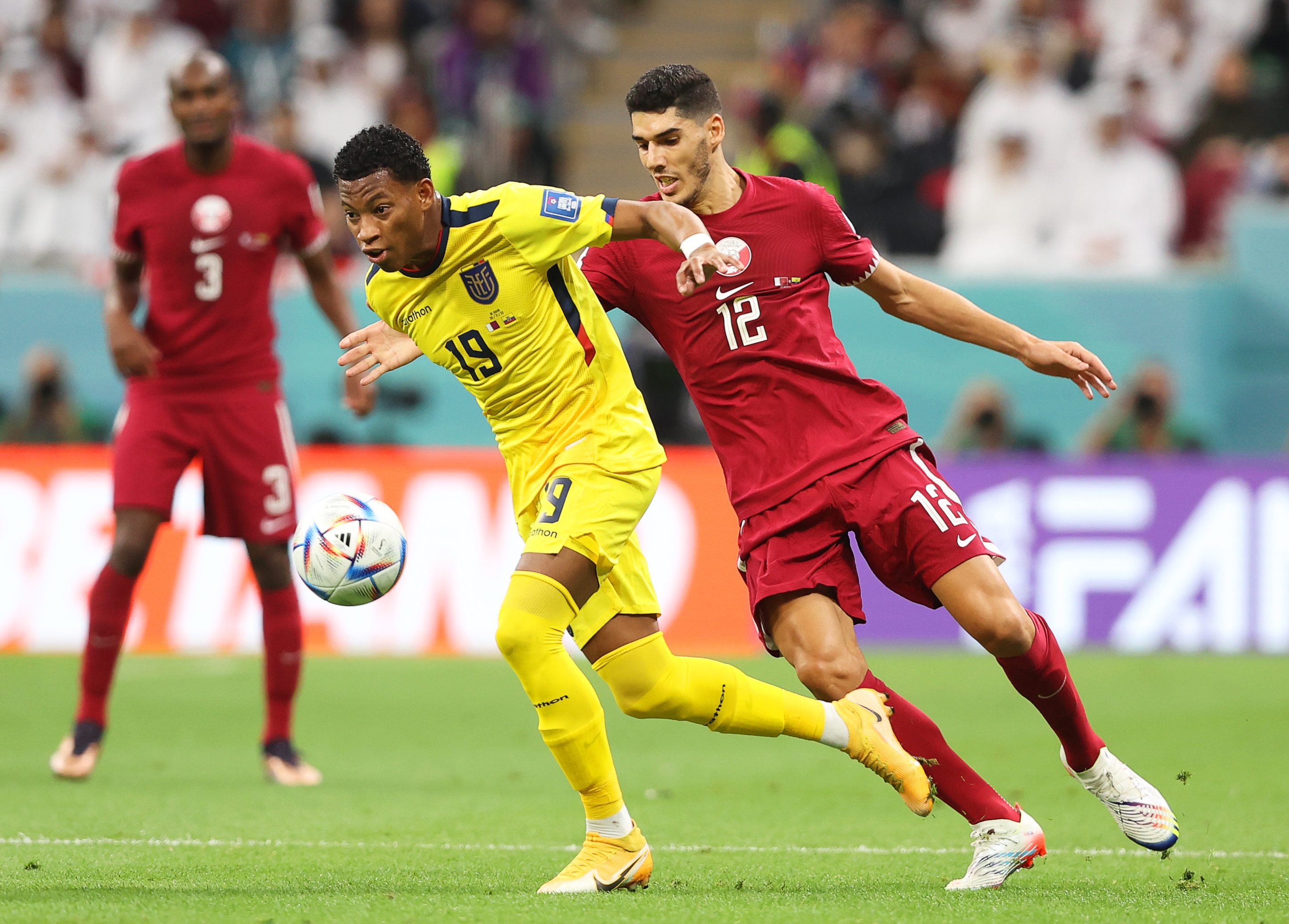 epa10316329 Karim Boudiaf (R) of Qatar in action against Gonzalo Plata (C) of Ecuador during the FIFA World Cup 2022 group A Opening Match between Qatar and Ecuador at Al Bayt Stadium in Al Khor, Qatar, 20 November 2022.  EPA-EFE/Tolga Bozoglu