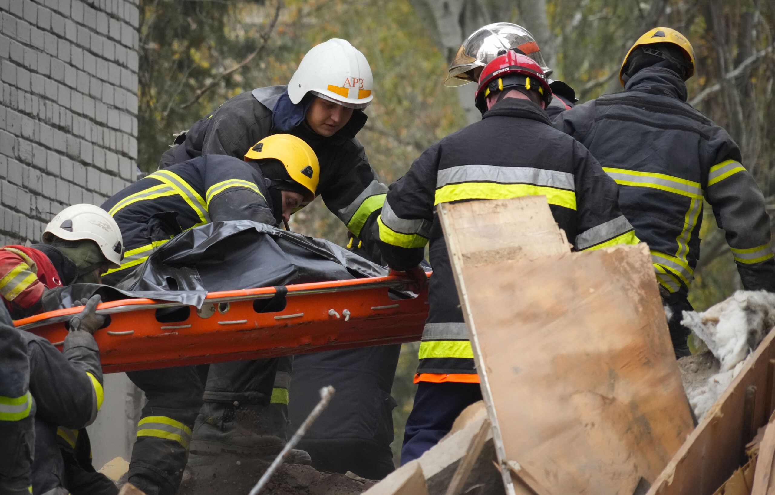 Ukrainian Emergency Service rescuers carry the lifeless body of a victim found under rubble at the scene of night shelling in Mykolaiv, Ukraine, Friday, Nov. 11, 2022. (AP Photo/Efrem Lukatsky)
