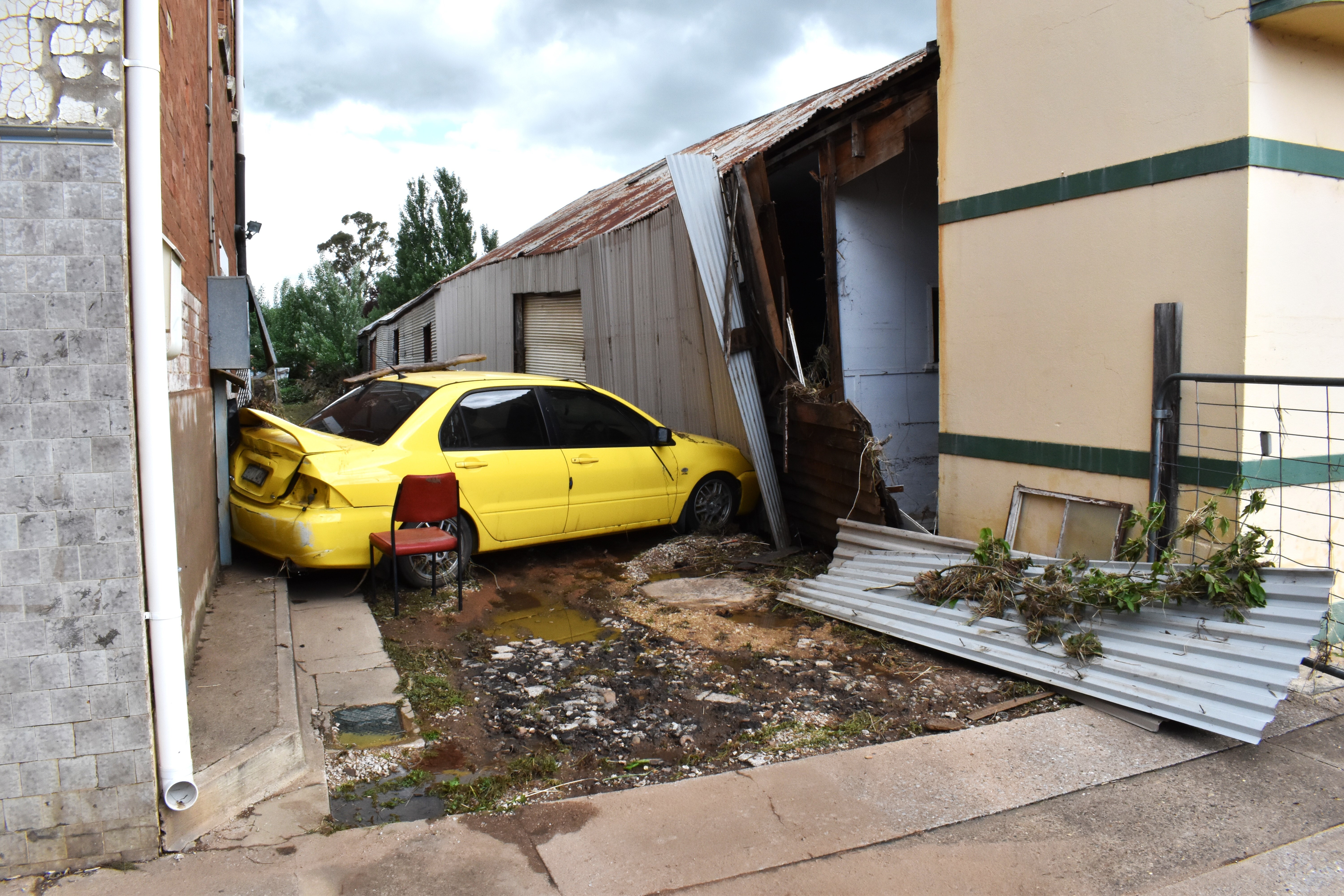 epa10304906 A car wedged in a laneway after being swept up in the aftermath of a flood in Molong, New South Wales, Australia, 14 November 2022.  EPA-EFE/MURRAY MCCLOSKEY AUSTRALIA AND NEW ZEALAND OUT