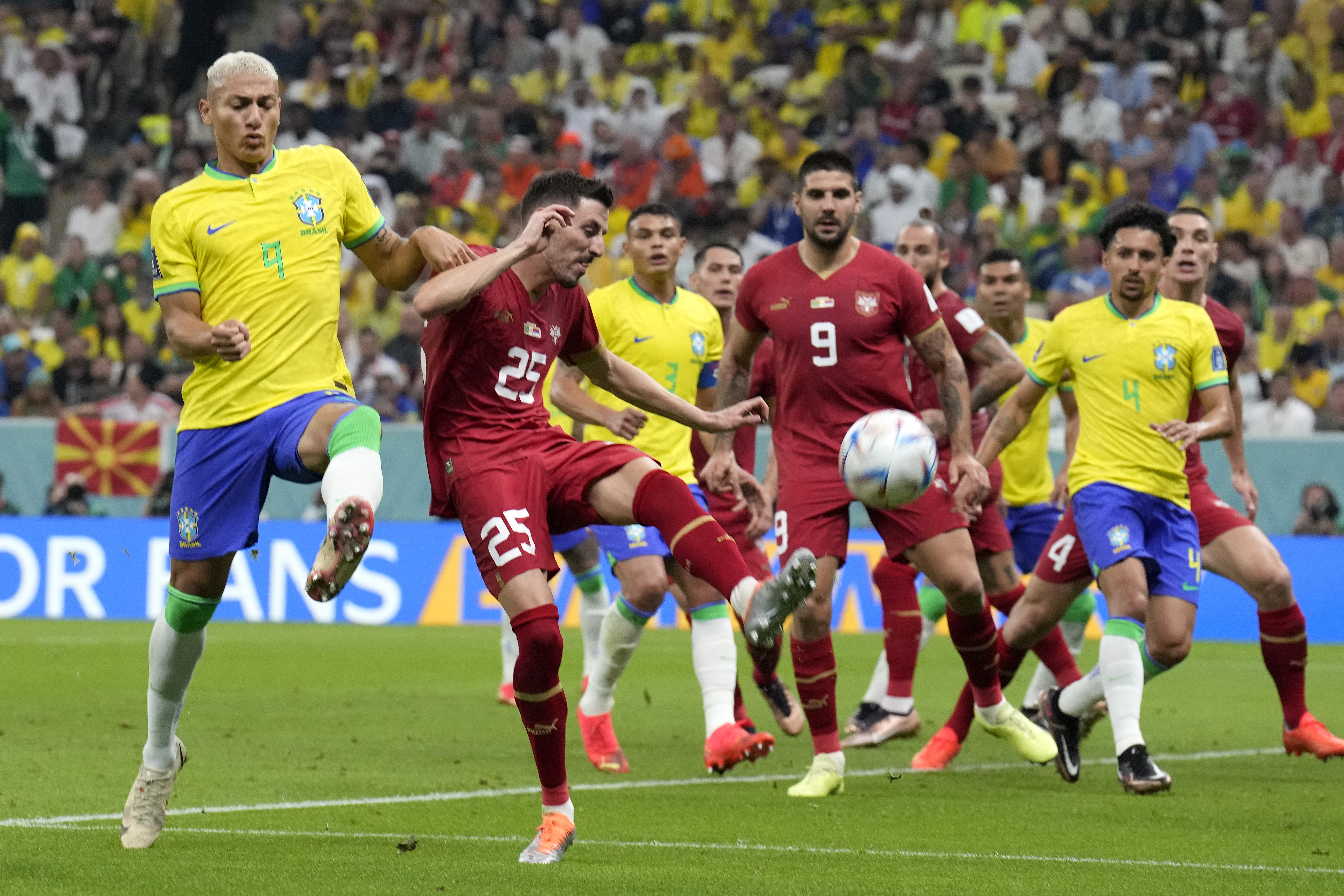 Brazil's Richarlison, left, challenges for the ball with Serbia's Filip Mladenovic during the World Cup group G soccer match between Brazil and Serbia, at the Lusail Stadium in Lusail, Qatar, Thursday, Nov. 24, 2022. (AP Photo/Natacha Pisarenko)