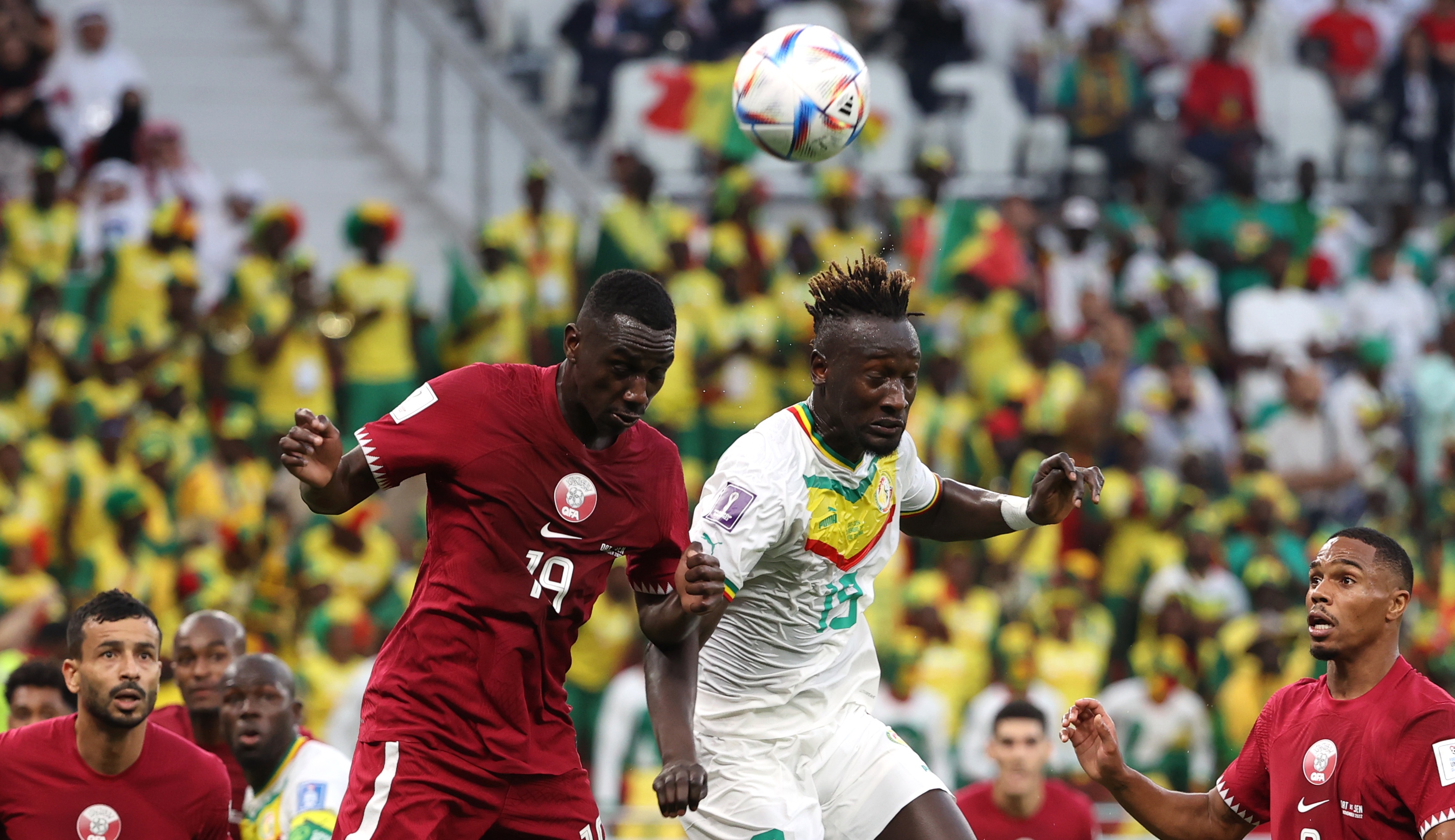 epa10327416 Almoez Ali (L) of Qatar in action against Famara Diedhiou of Senegal during the FIFA World Cup 2022 group A soccer match between Qatar and Senegal at Al Thumama Stadium in Doha, Qatar, 25 November 2022.  EPA-EFE/Ali Haider