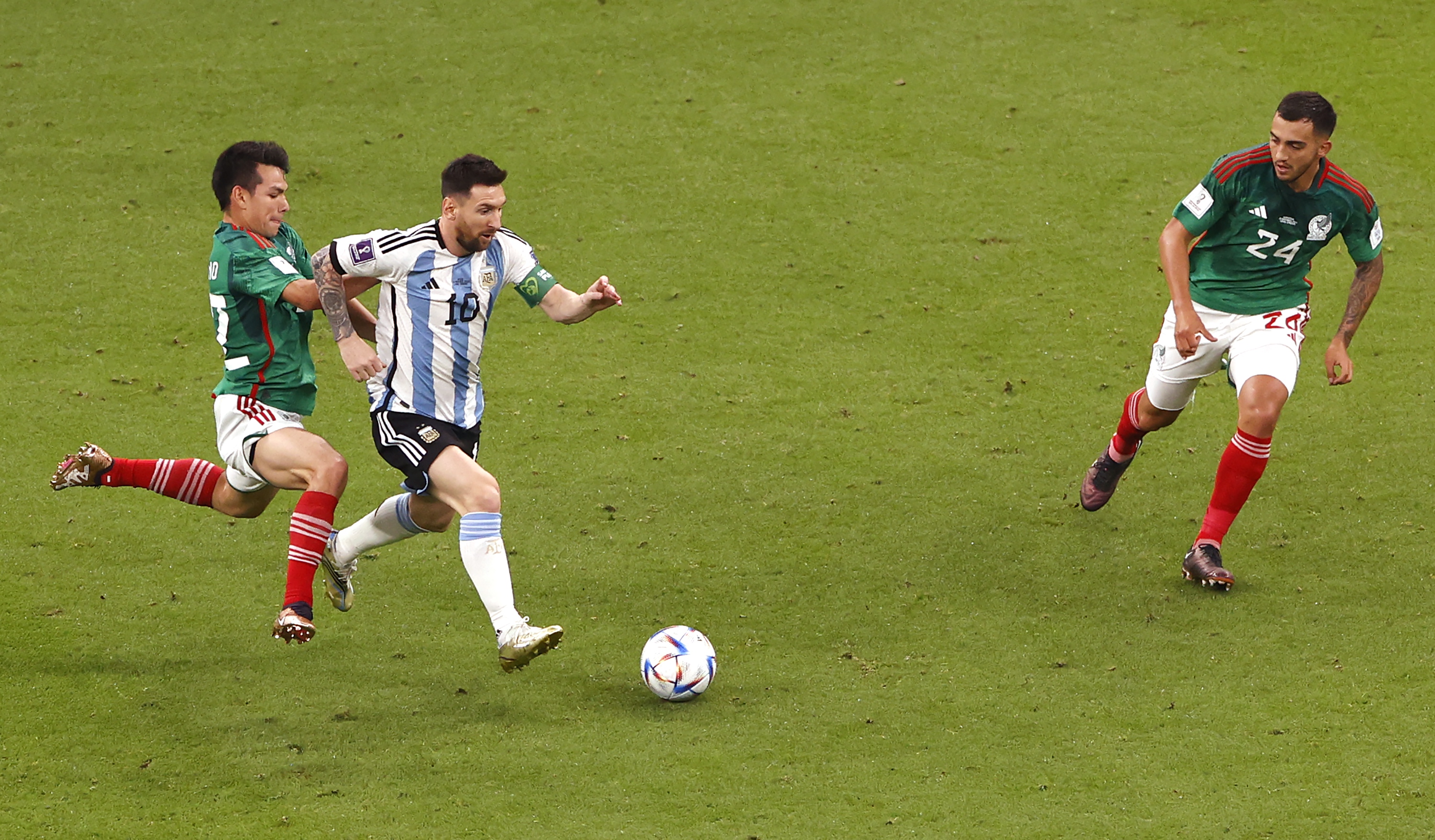epa10331045 Lionel Messi (C) of Argentina in action against Hirving Lozano (L) of Mexico during the FIFA World Cup 2022 group C soccer match between Argentina and Mexico at Lusail Stadium in Lusail, Qatar, 26 November 2022.  EPA-EFE/Rungroj Yongrit