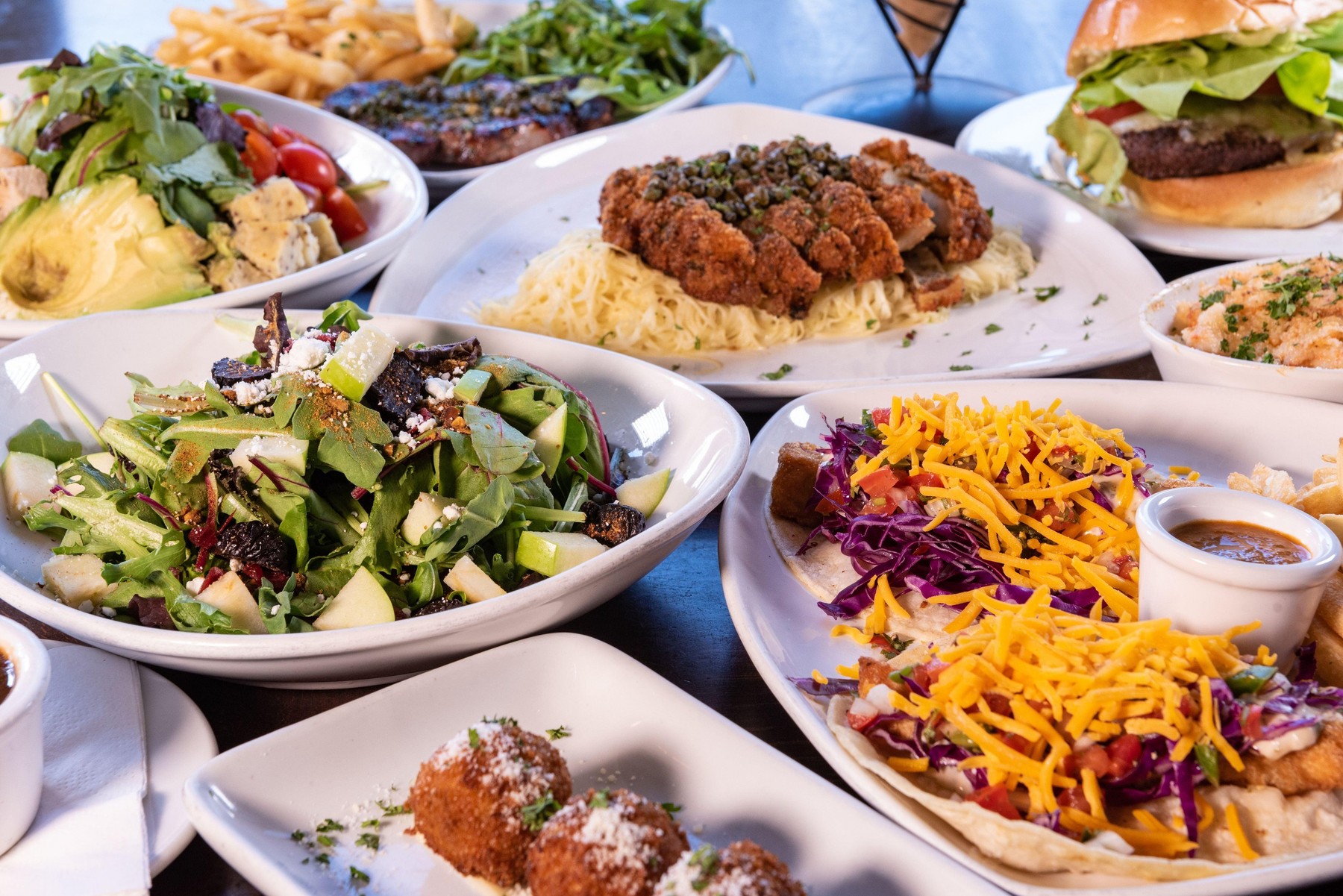 Fish tacos surrounded by tasty plates of food from the Bistro served buffet style on the table.