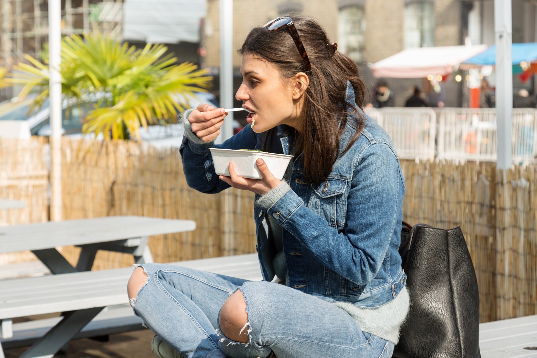 Young women eating takeaway food on picnic bench
