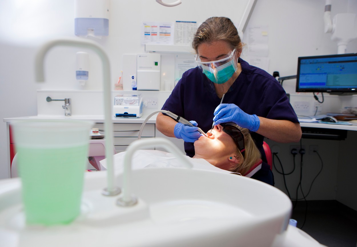 MODEL RELEASED. Patient in dentist's chair, dentist working on teeth.,Image: 308034175, License: Royalty-free, Restrictions: Editorial use only, Model Release: yes, Credit line: LEWIS HOUGHTON / Sciencephoto / Profimedia