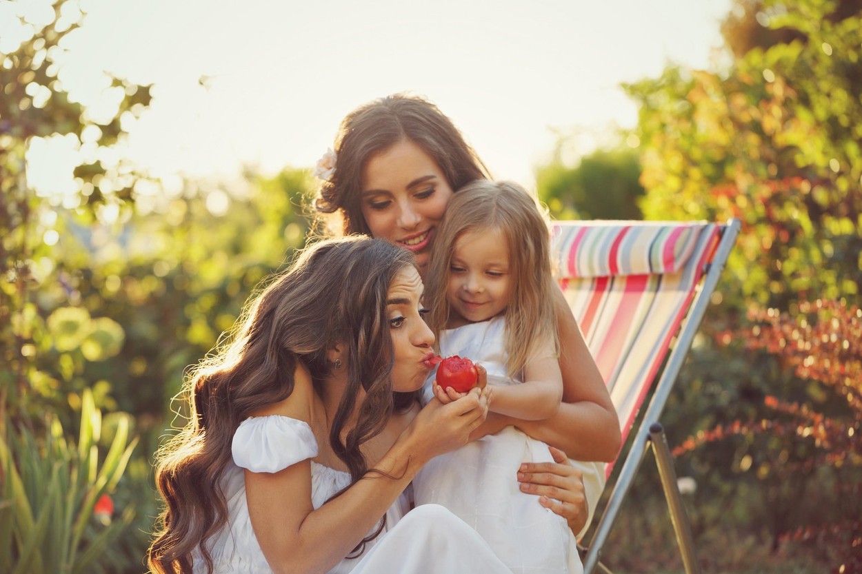 Three sisters. Girls eating a tomato in the garden. Family time. Human relationships. Setting sun. Fun.,Image: 300238359, License: Royalty-free, Restrictions: , Model Release: yes, Credit line: Elena Vagengeym / Alamy / Alamy / Profimedia