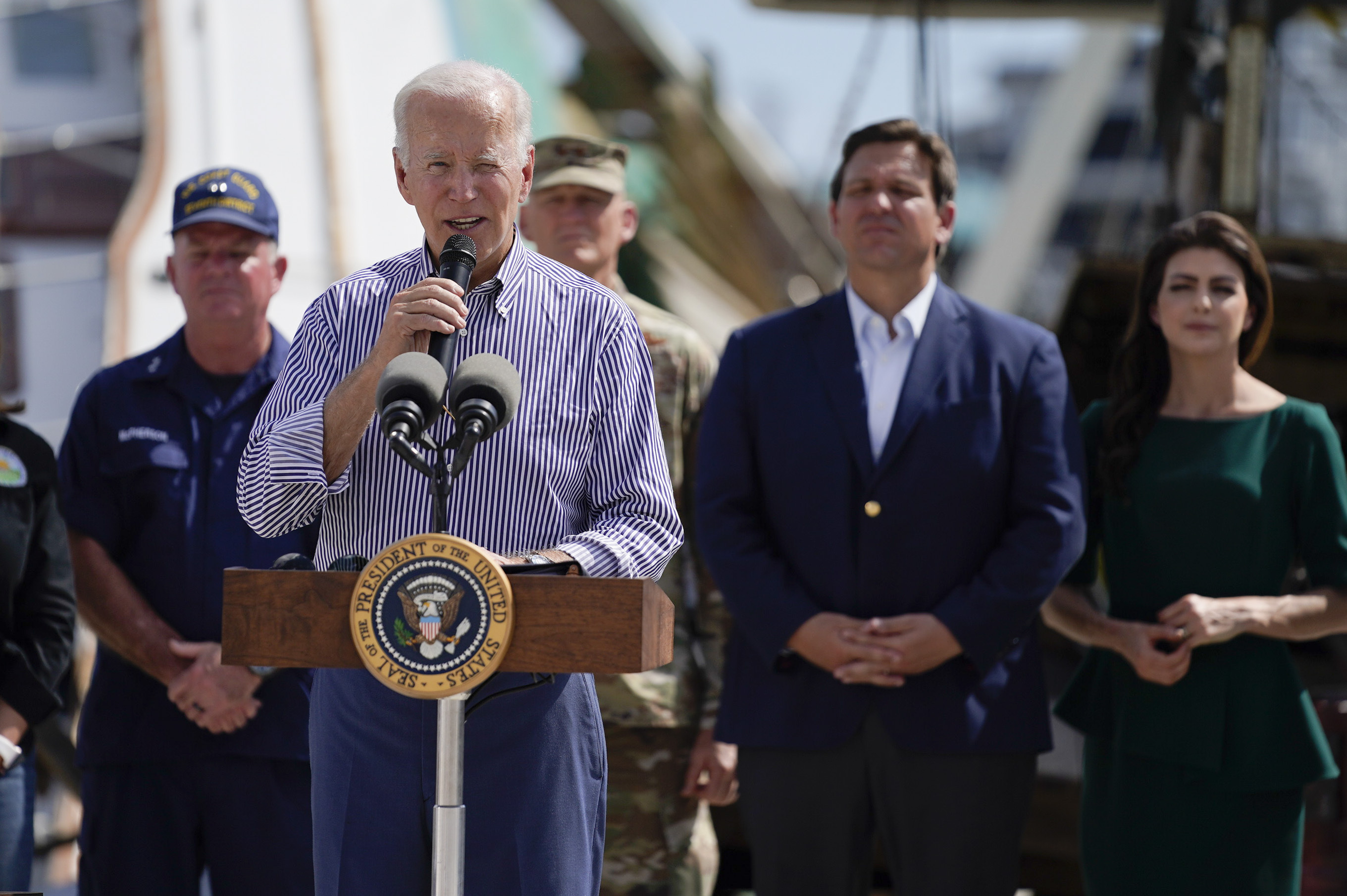 President Joe Biden speaks after touring an area impacted by Hurricane Ian on Wednesday, Oct. 5, 2022, in Fort Myers Beach, Fla. Florida Gov. Ron DeSantis, second from right, and his wife Casey DeSantis listen. (AP Photo/Evan Vucci)