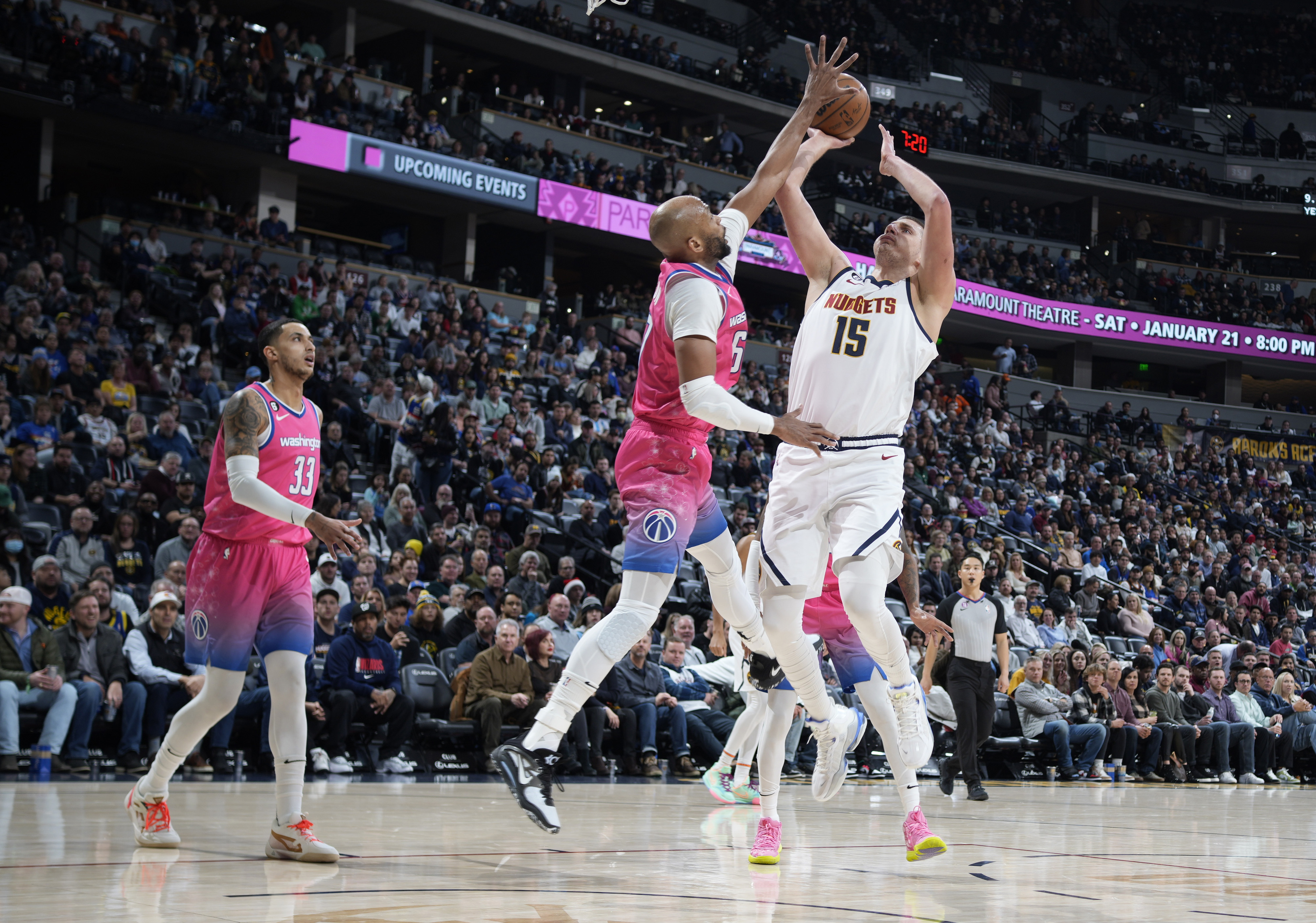 Washington Wizards forward Taj Gibson, left, blocks a shot by Denver Nuggets center Nikola Jokic in the first half of an NBA basketball game Wednesday, Dec. 14, 2022, in Denver. (AP Photo/David Zalubowski)