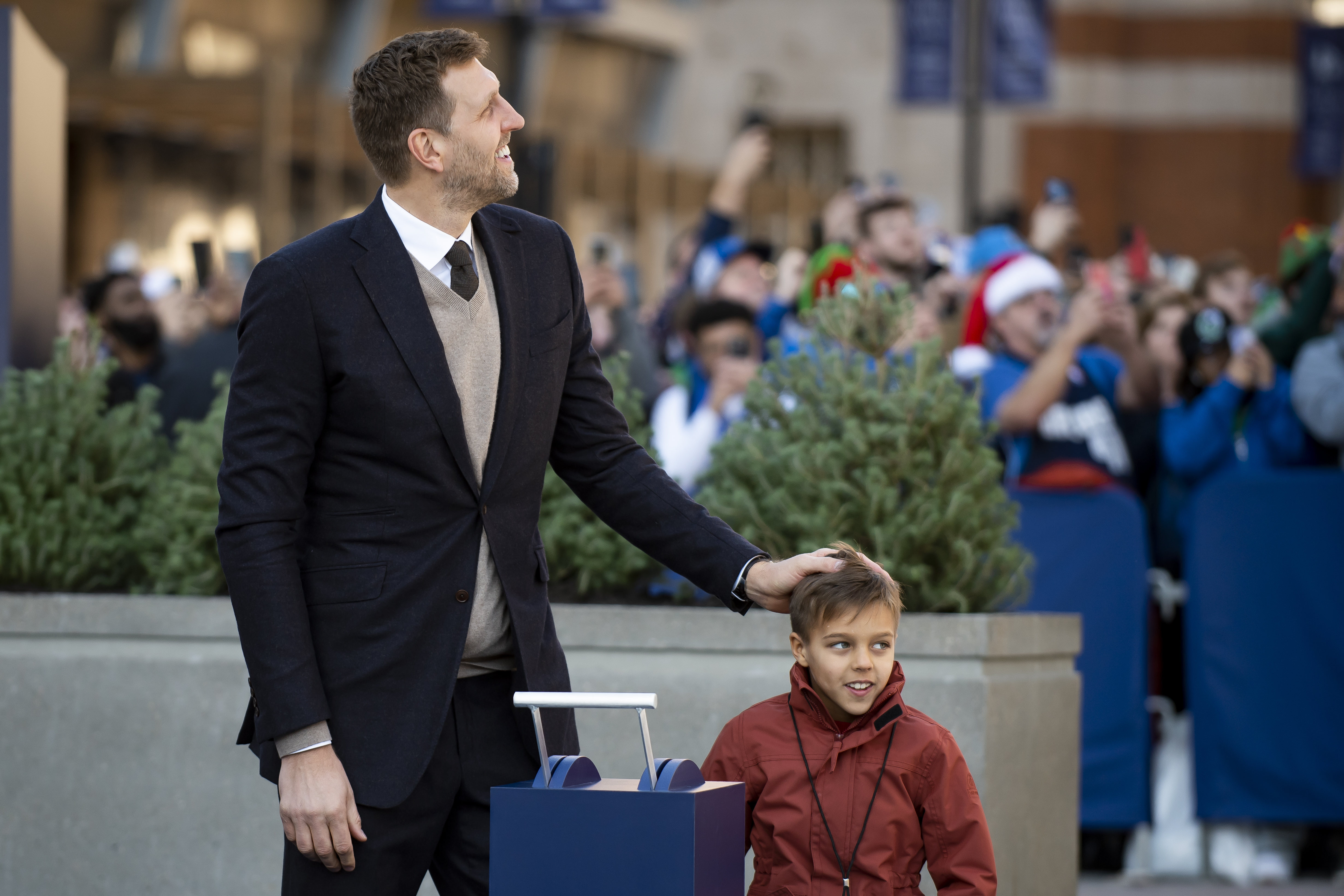 Dirk Nowitzki places his hand on his son, Max,as he unveils his statue during the "All Four One" statue ceremony in front of the American Airlines Center in Dallas, Sunday, Dec. 25, 2022. (AP Photo/Emil T. Lippe)