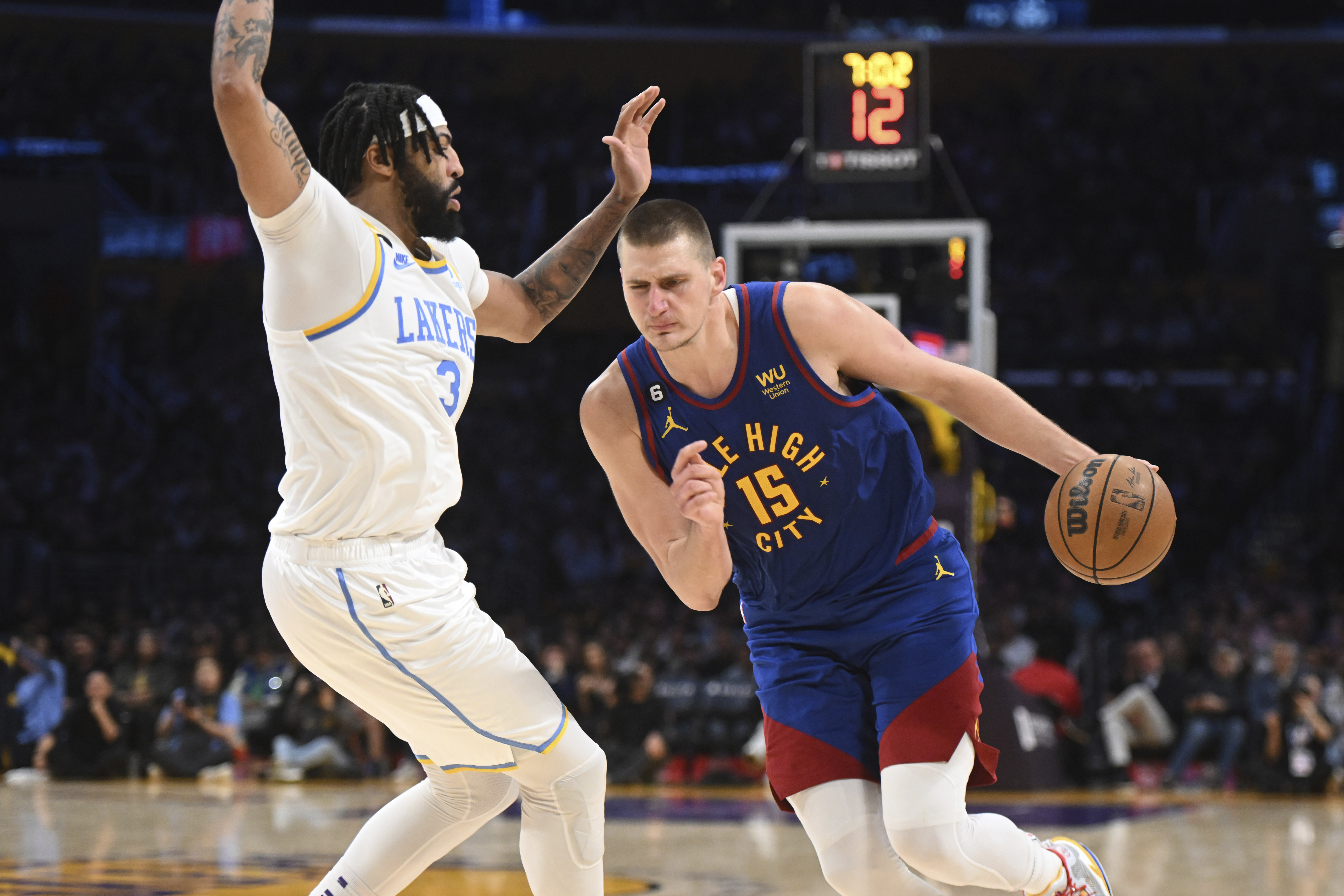 Denver Nuggets center Nikola Jokic (15) drives against Los Angeles Lakers forward Anthony Davis (3) during an NBA basketball game Sunday, Oct. 30, 2022, in Los Angeles. The Lakers won 121-110. (AP Photo/Michael Owen Baker)