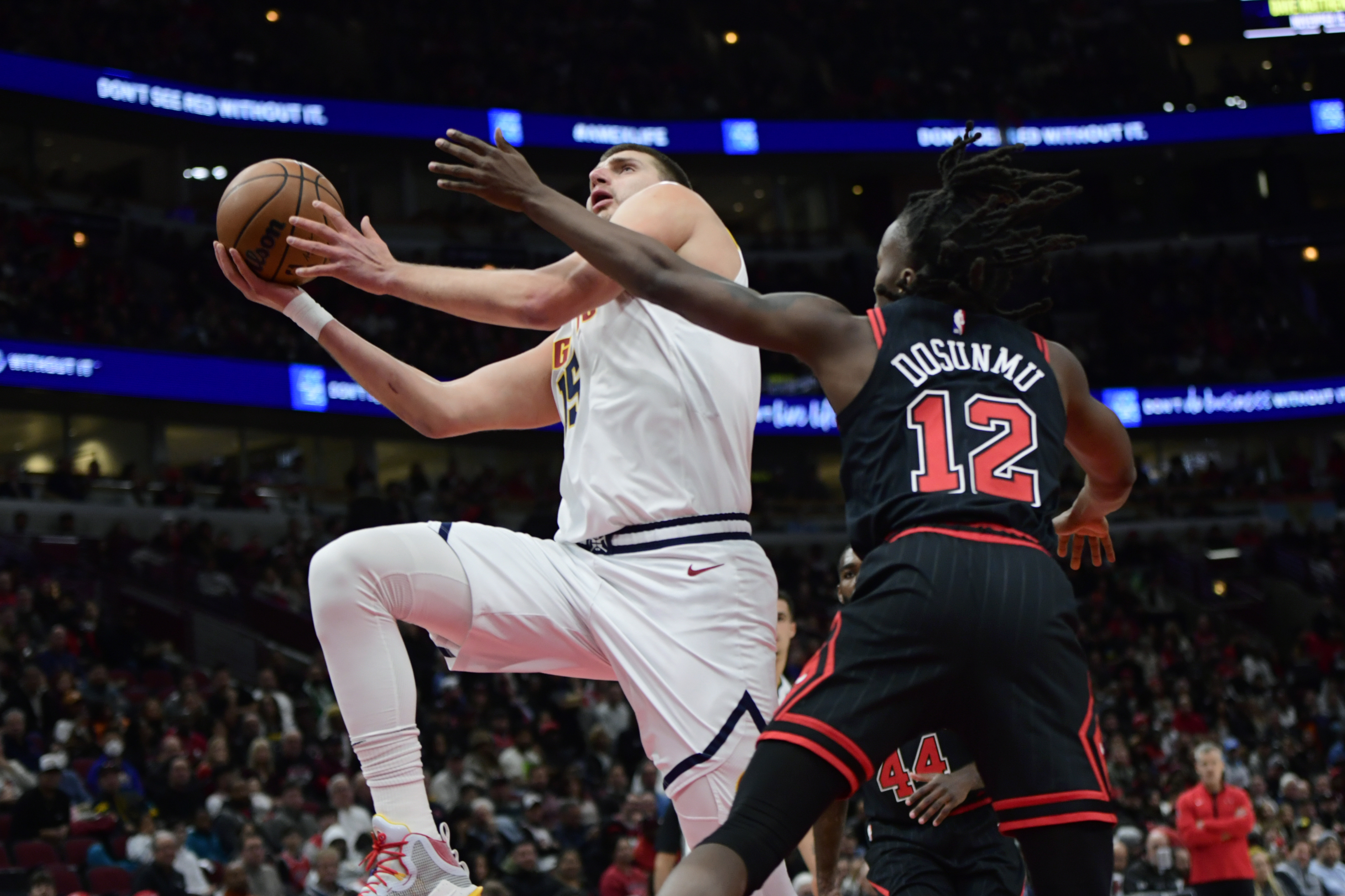 Denver Nuggets' Nikola Jokic (15) goes up to shoot against Chicago Bulls' Ayo Dosunmu (12) during the first half of an NBA basketball game Sunday, Nov. 13, 2022, in Chicago. (AP Photo/Paul Beaty)