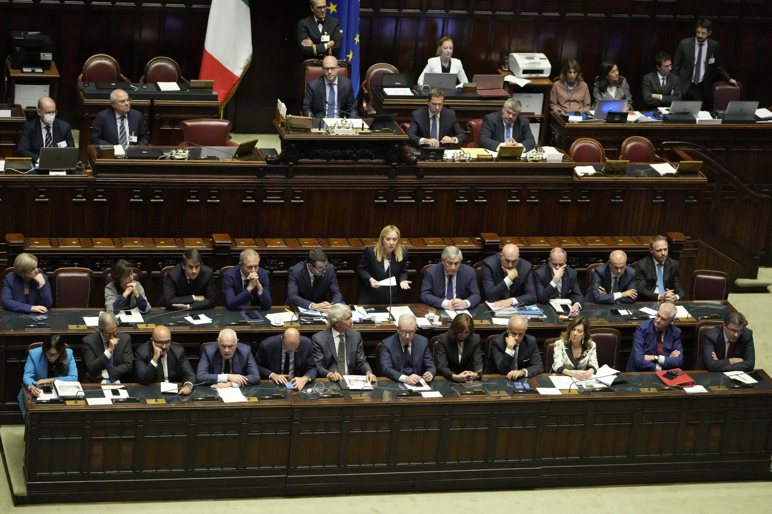 Italian Premier Giorgia Meloni, standing at center, delivers her speech at the lower Chamber ahead of a confidence vote for her Cabinet, Tuesday, Oct. 25, 2022. (AP Photo/Alessandra Tarantino)