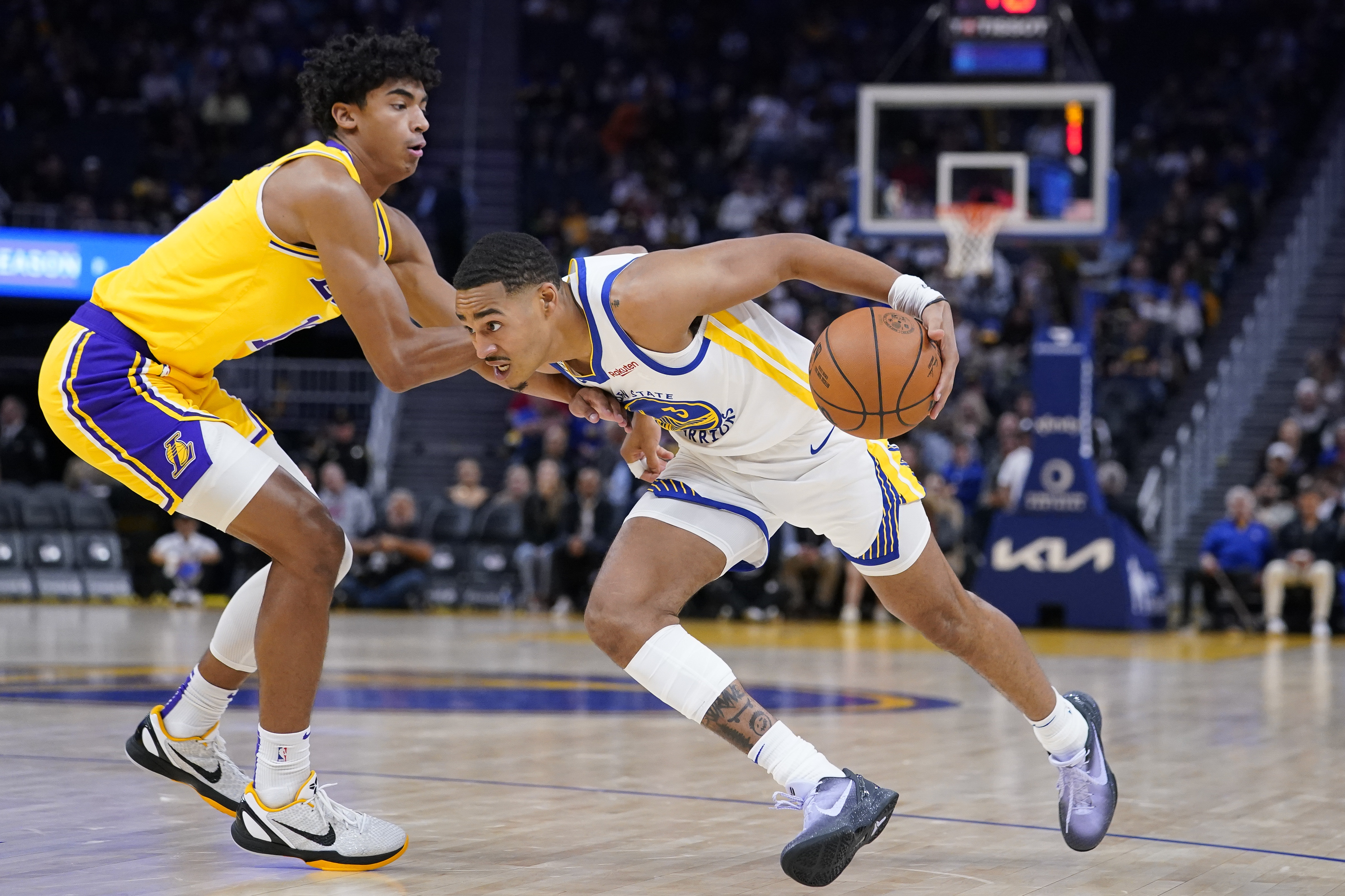 Golden State Warriors guard Jordan Poole, right, gets around Los Angeles Lakers guard Max Christie, left, during the first half of a basketball game in San Francisco, Sunday, Oct. 9, 2022. (AP Photo/Godofredo A. Vásquez)