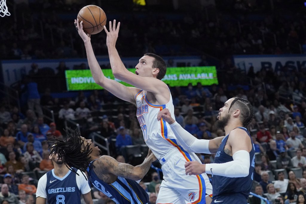 Oklahoma City Thunder center Aleksej Pokusevski (17) collides with Memphis Grizzlies guard Ja Morant (12) and is called for a foul in the first half of an NBA basketball game Sunday, March 13, 2022, in Oklahoma City. (AP Photo/Sue Ogrocki)