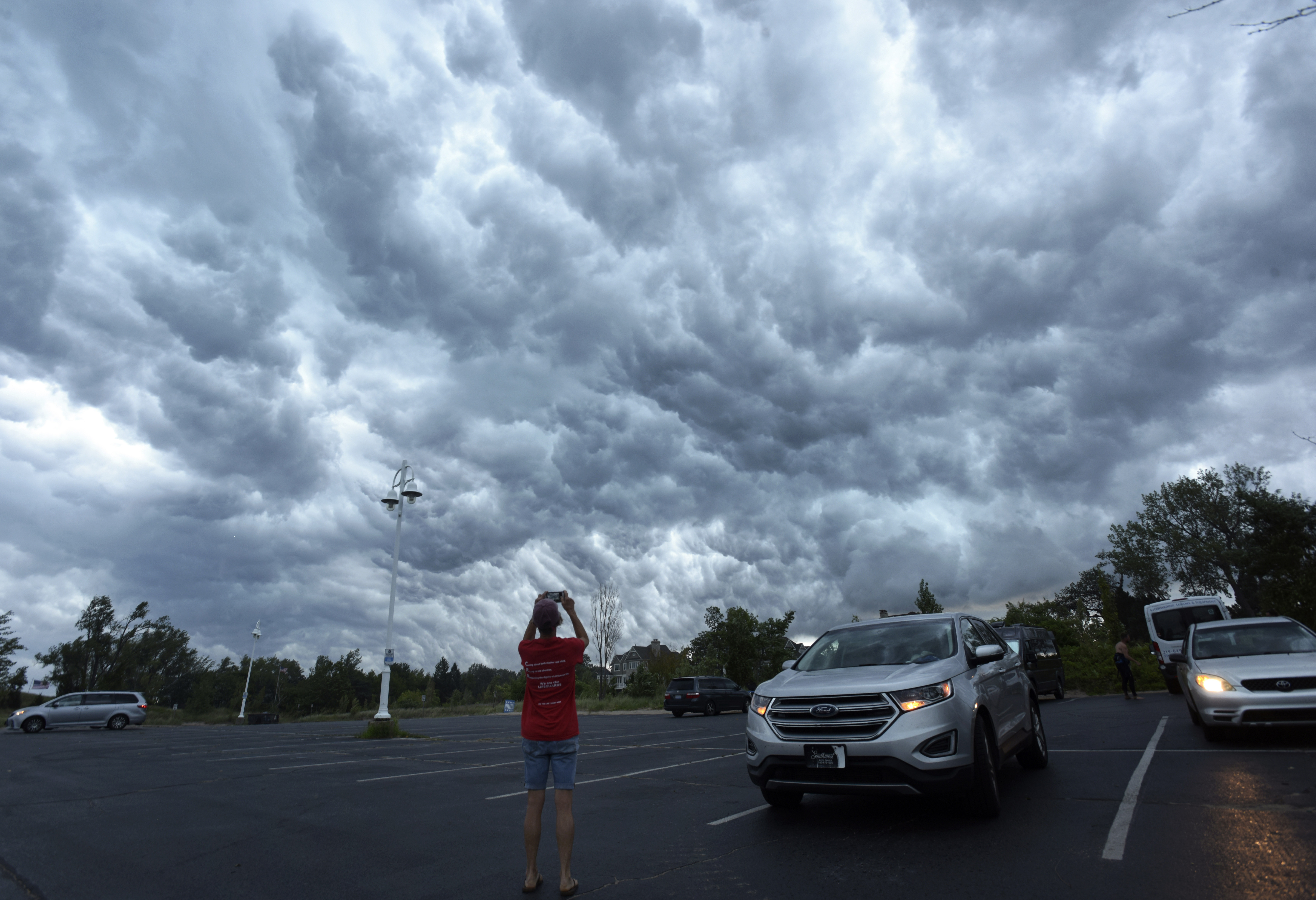 Beachgoers head to their cars at Tiscornia Beach as a front moves in over Lake Michigan and St. Joseph, Mich., Monday, Aug. 29, 2022. (Don Campbell/The Herald-Palladium via AP)