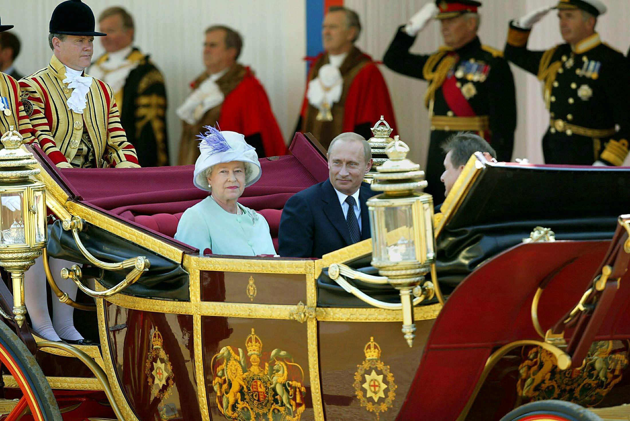 Russian President Vladimir Putin and Britain's Queen Elizabeth II leave in an open carriage