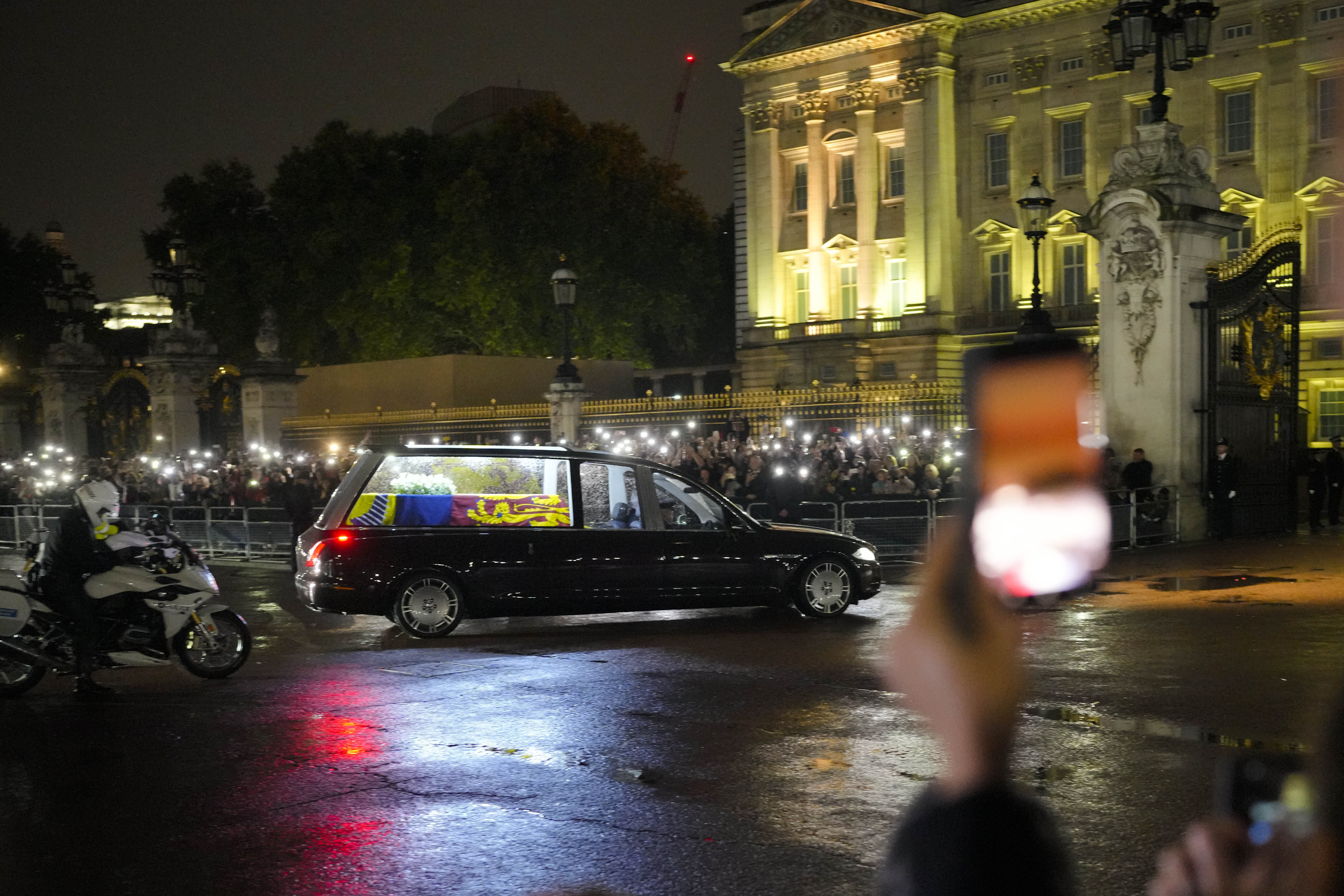 The hearse carrying Queen Elizabeth's coffin arrives at Buckingham Palace in London, Tuesday, Sept. 13, 2022. (AP Photo/Markus Schreiber)