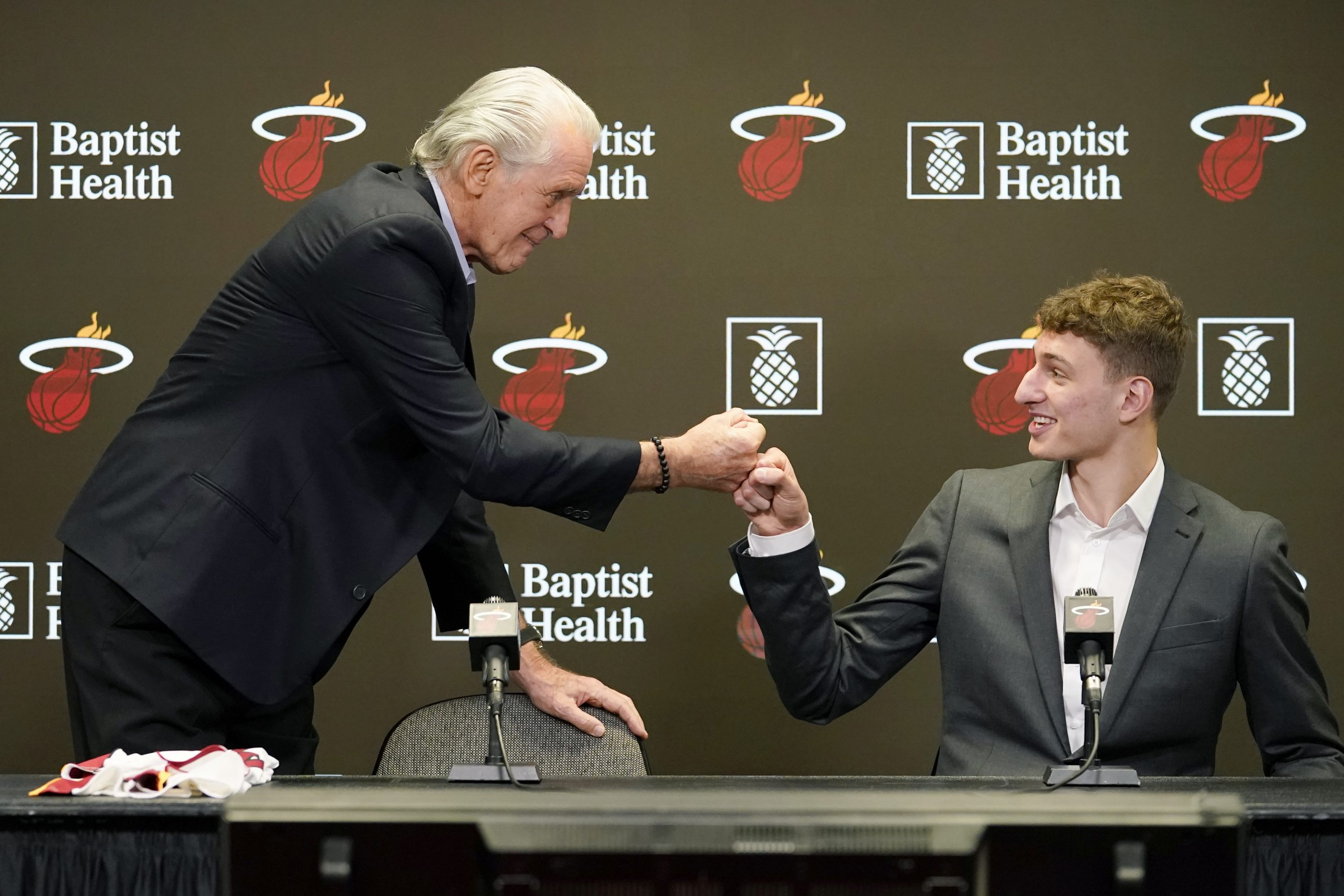 Miami Heat president Pat Riley, left, bumps fists with Nikola Jovic, of Serbia, right, during a news conference, Monday, June 27, 2022, in Miami. Jovic was selected by the Miami Heat as the No. 27 pick in the 2022 NBA draft. (AP Photo/Lynne Sladky)