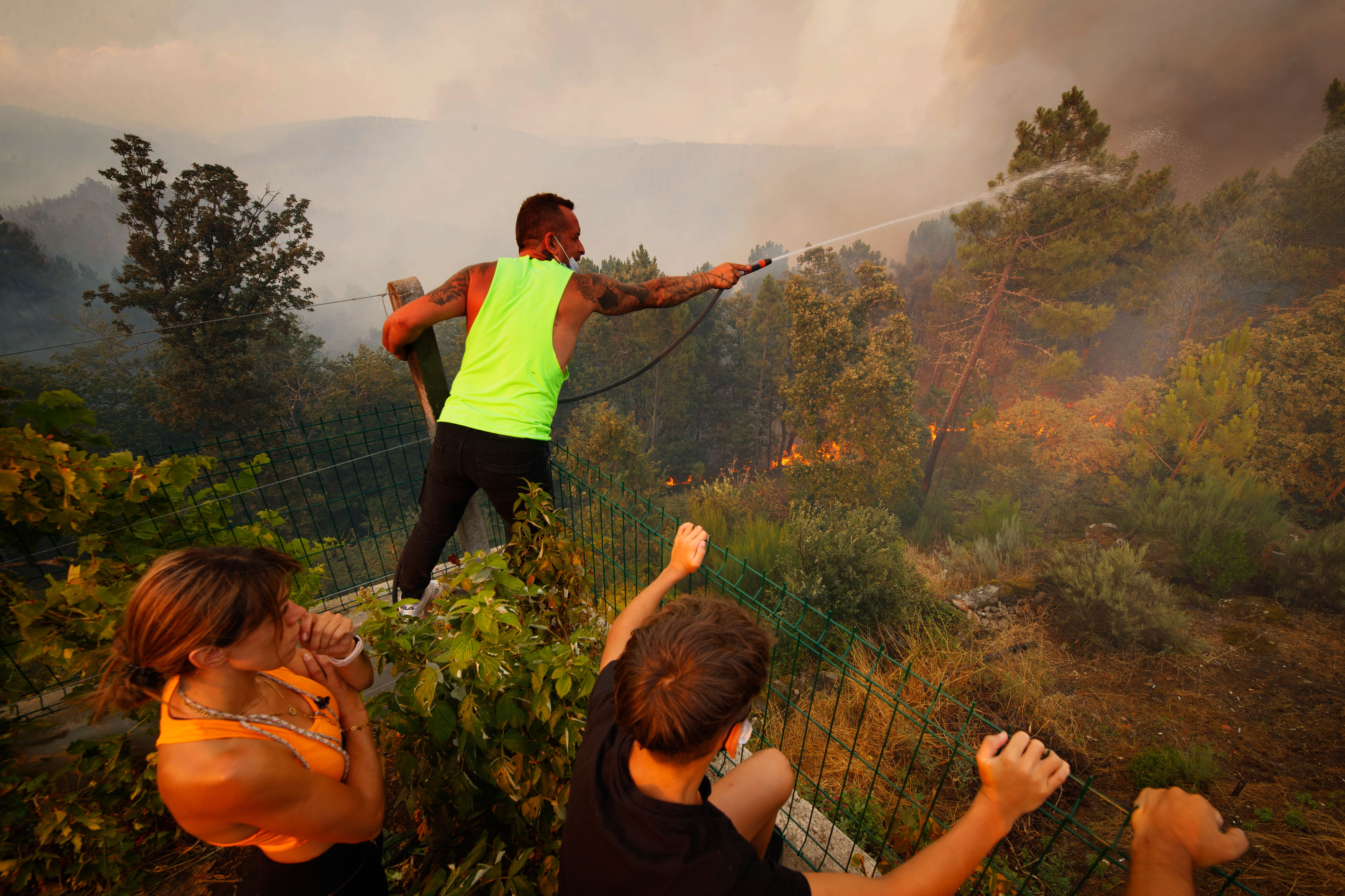 epaselect epa10096111 A person fights a forest fire in Reboredo village, Vila Pouca de Aguiar, Portugal, 28 July 2022. A total of 466 operational, 144 vehicles and six airplane are fighting the forest fire.  EPA-EFE/PEDRO SARMENTO COSTA