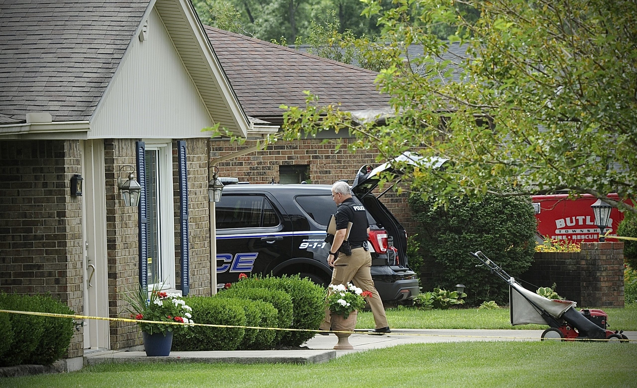 Police investigate a shooting Friday, Aug. 5, 2022, in Butler Township, Ohio.  Authorities say four people were shot to death in the Ohio suburb and a man considered armed and dangerous is being sought. (Marshall Gorby /Dayton Daily News via AP)