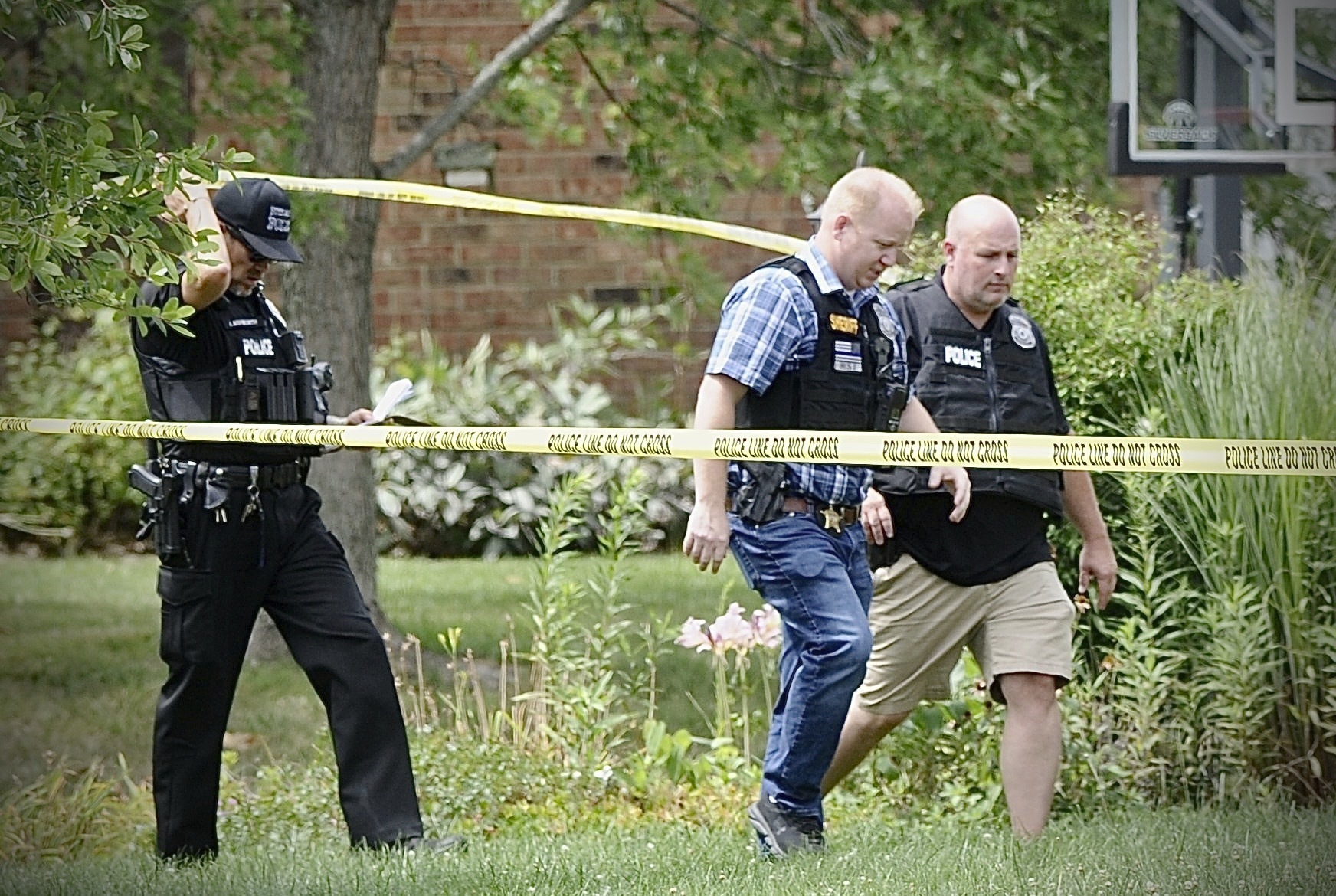 Police investigate a shooting Friday, Aug. 5, 2022, in Butler Township, Ohio.  Authorities say four people were shot to death in the Ohio suburb and a man considered armed and dangerous is being sought. (Marshall Gorby /Dayton Daily News via AP)