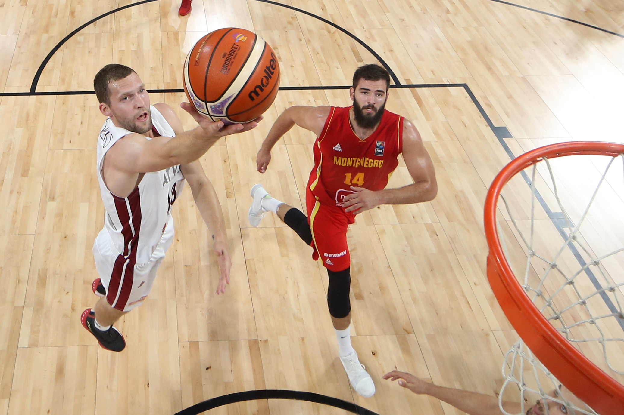 epa06195747 Latvia's Janis Strelnieks (L) in action against Montenegro's Bojan Dubljevic (R) during the EuroBasket 2017 round of top 16 match between Latvia and Montenegro, in Istanbul, Turkey, 10 September 2017.  EPA-EFE/TOLGA BOZOGLU