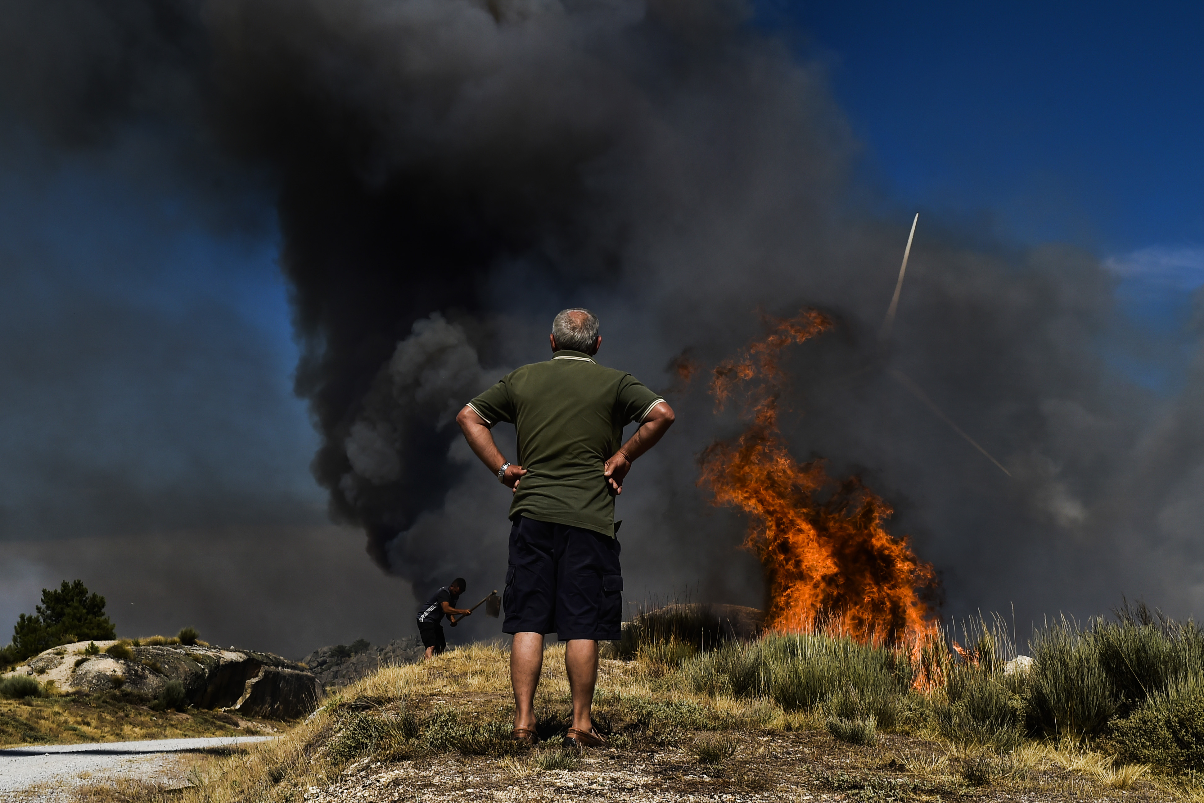 epa10119192 A man observes a forest fire in Rapa, Celorico da Beira, Guarda, Portugal, 13 August 2022. At the moment 1327 operational, 392 vehicles and three airplane are fighting the forest fire.  EPA-EFE/NUNO ANDRE FERREIRA