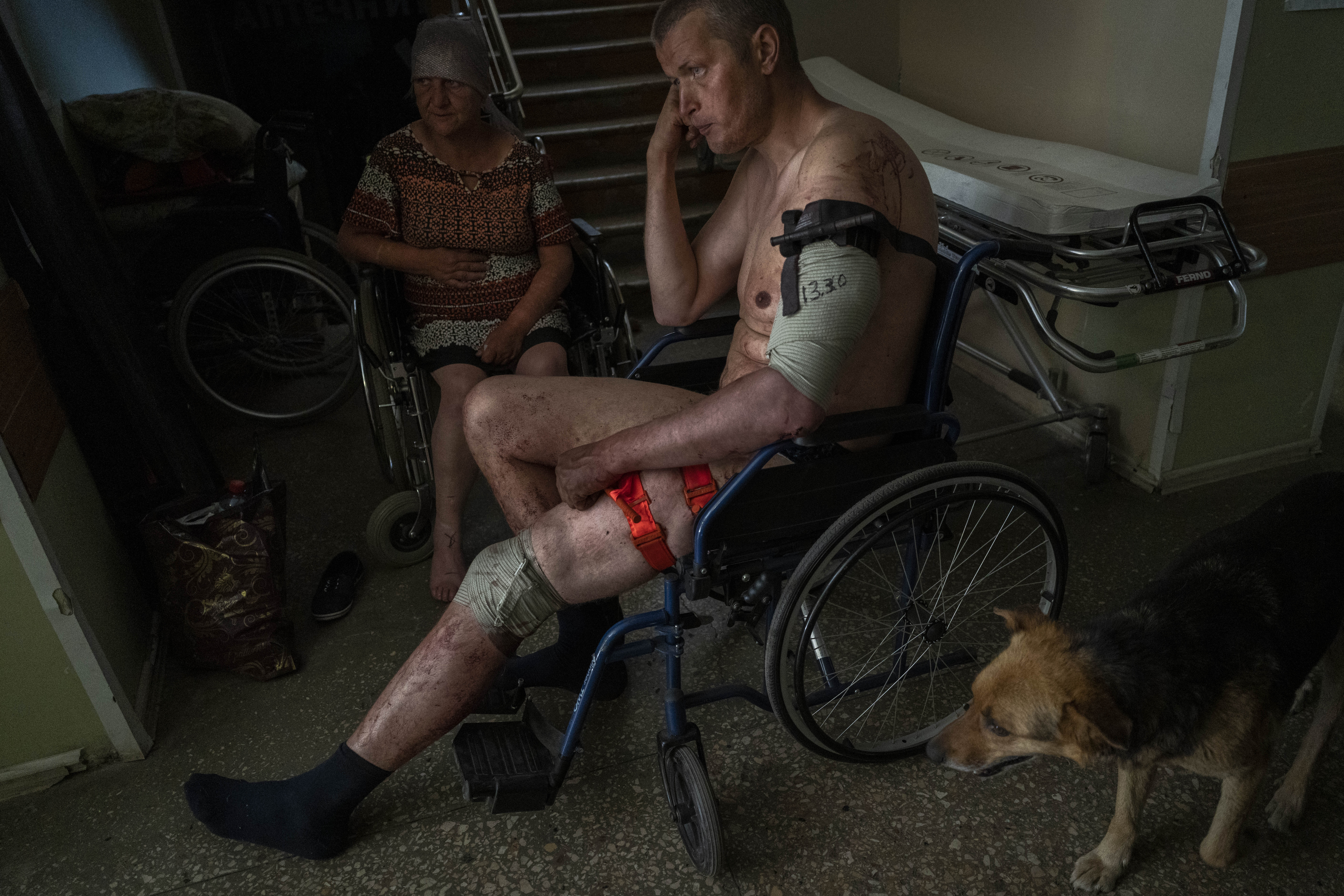 An Ukrainian injured serviceman and an injured civilian wait for medical treatment in Bakhmut, eastern Ukraine, Tuesday, June 7, 2022. (AP Photo/Bernat Armangue)