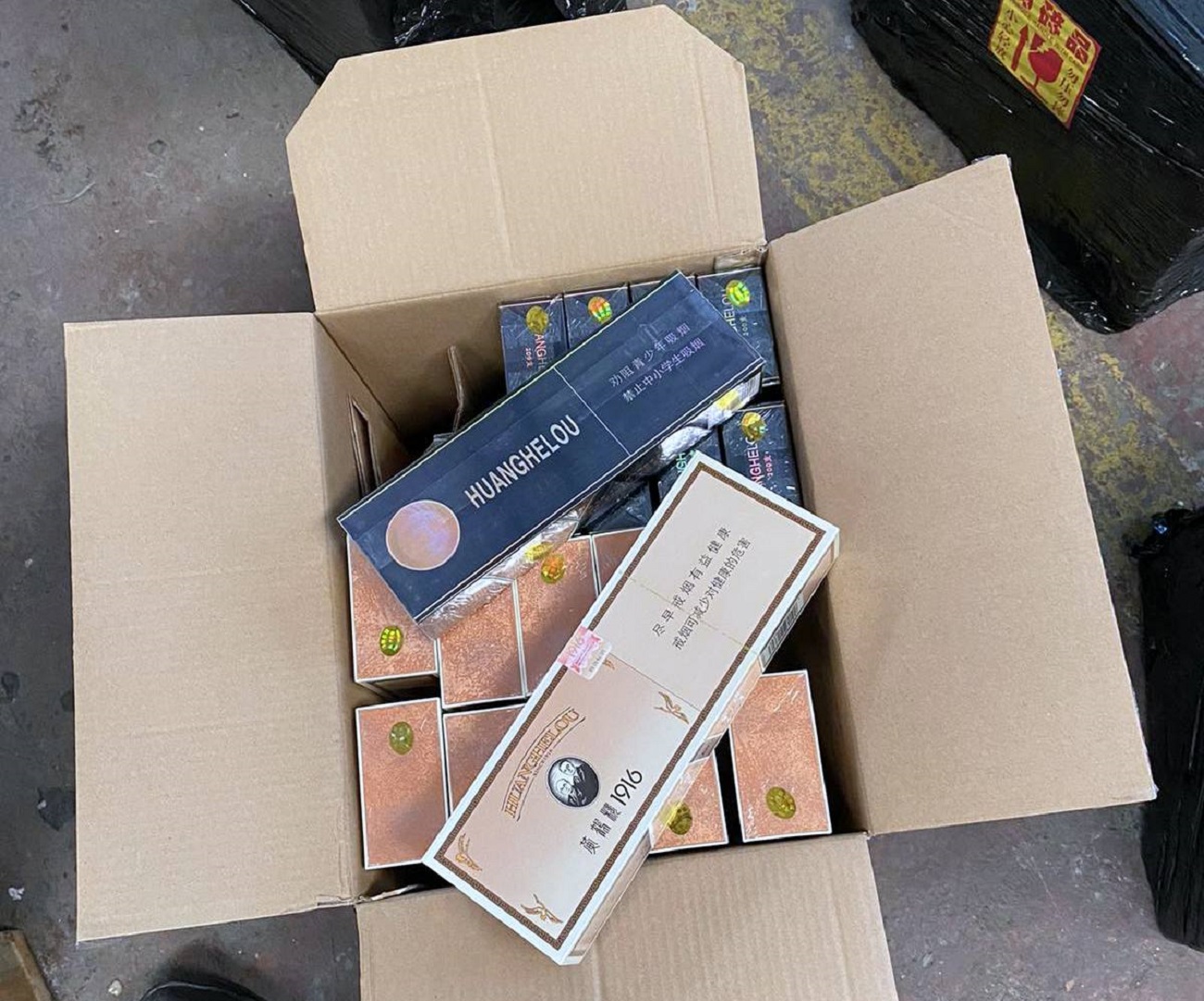 luksuzna alkoholna pića i cigarete u kontejneru mašina i alata