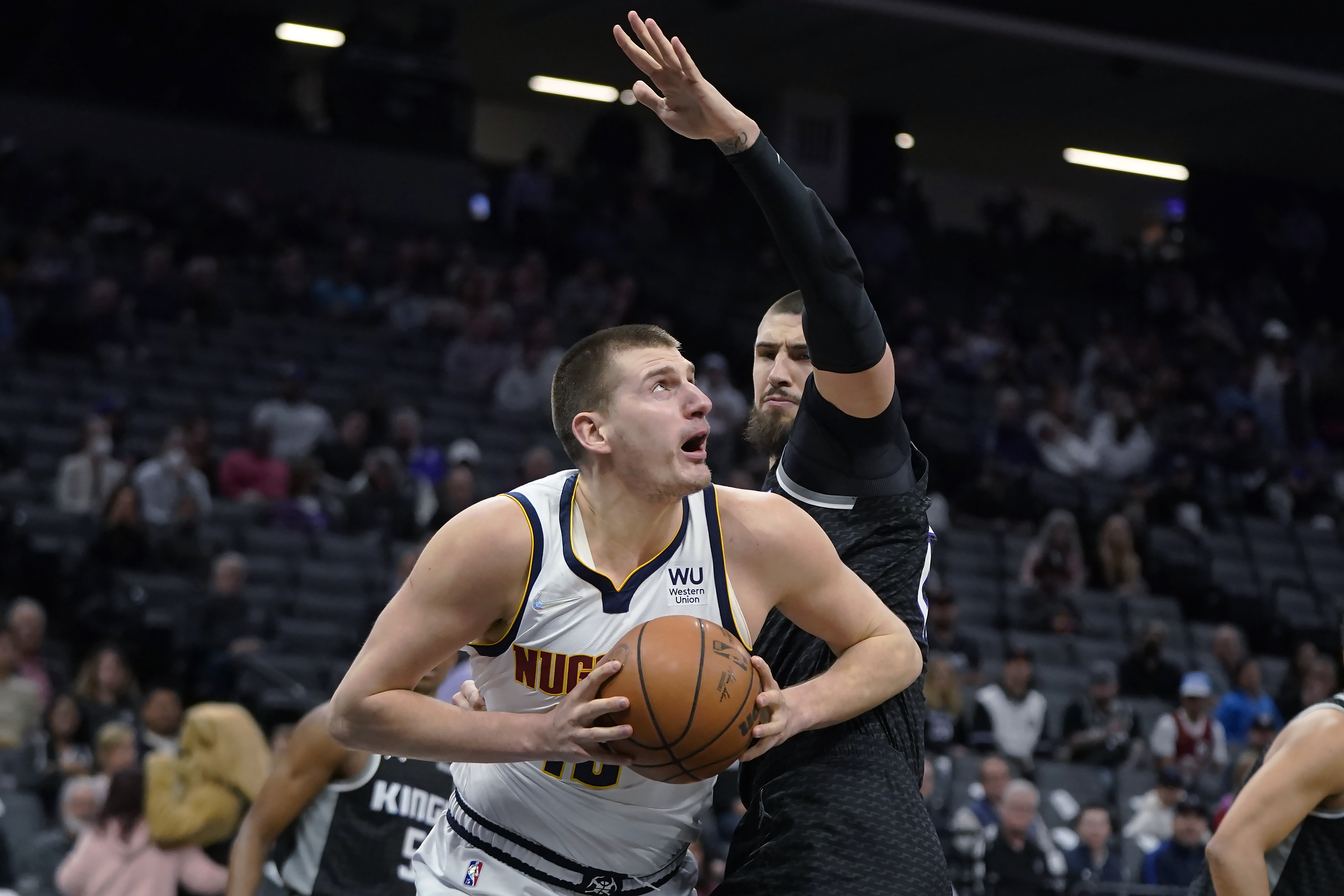 Denver Nuggets center Nikola Jokic drives to the basket against Sacramento Kings center Alex Len during the first half of an NBA basketball game in Sacramento, Calif., Wednesday, March 9, 2022. (AP Photo/Jeff Chiu)
