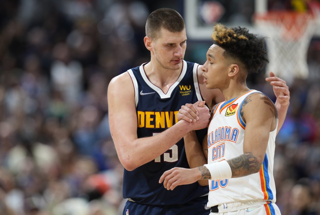 Denver Nuggets center Nikola Jokic, left, greets Oklahoma City Thunder guard Tre Mann after an NBA basketball game Saturday, March 26, 2022, in Denver. (AP Photo/David Zalubowski)