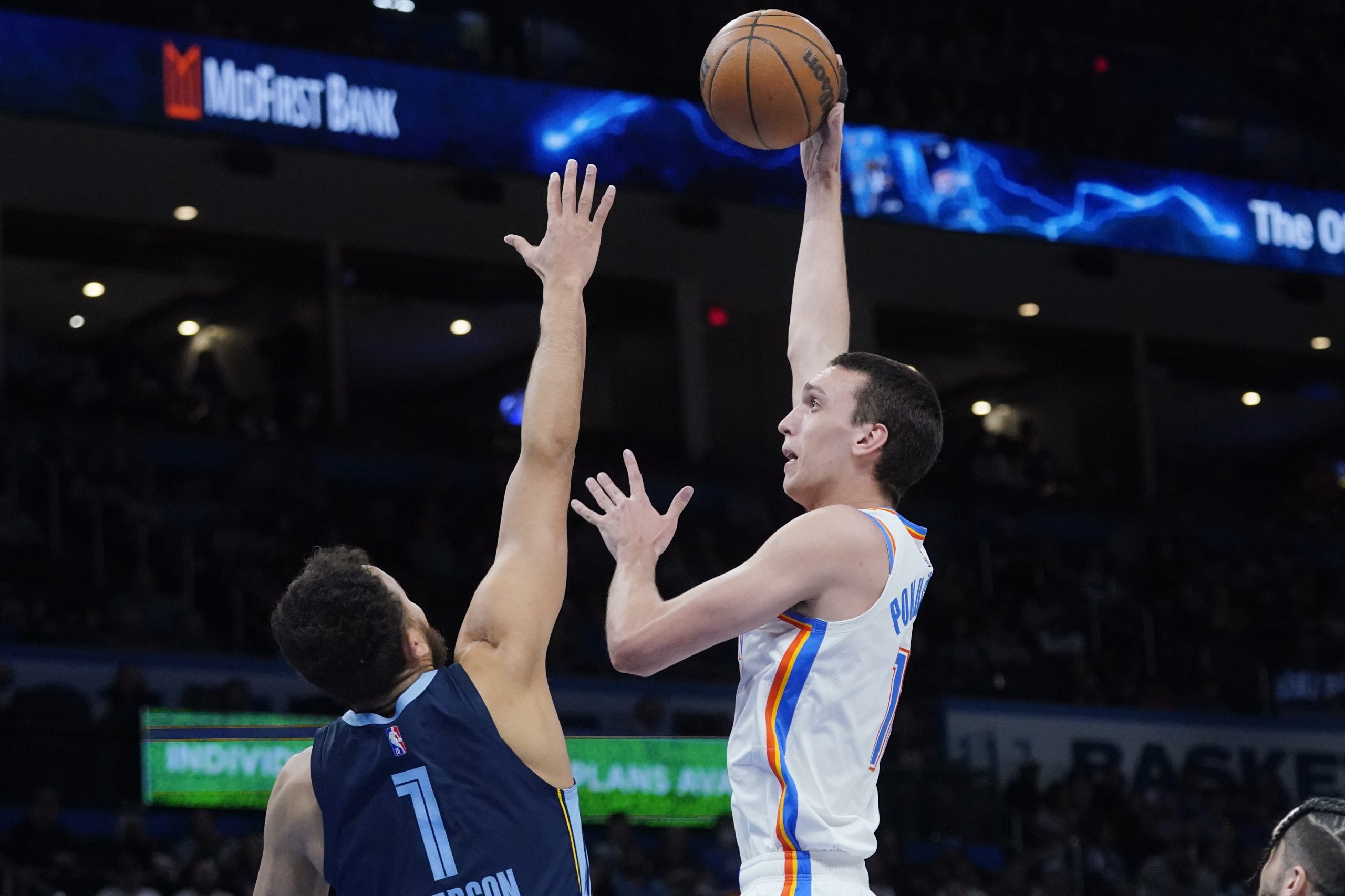 Oklahoma City Thunder center Aleksej Pokusevski, right, shoots ovdefr Memphis Grizzlies forward Kyle Anderson (1) in the first half of an NBA basketball game Sunday, March 13, 2022, in Oklahoma City. (AP Photo/Sue Ogrocki)