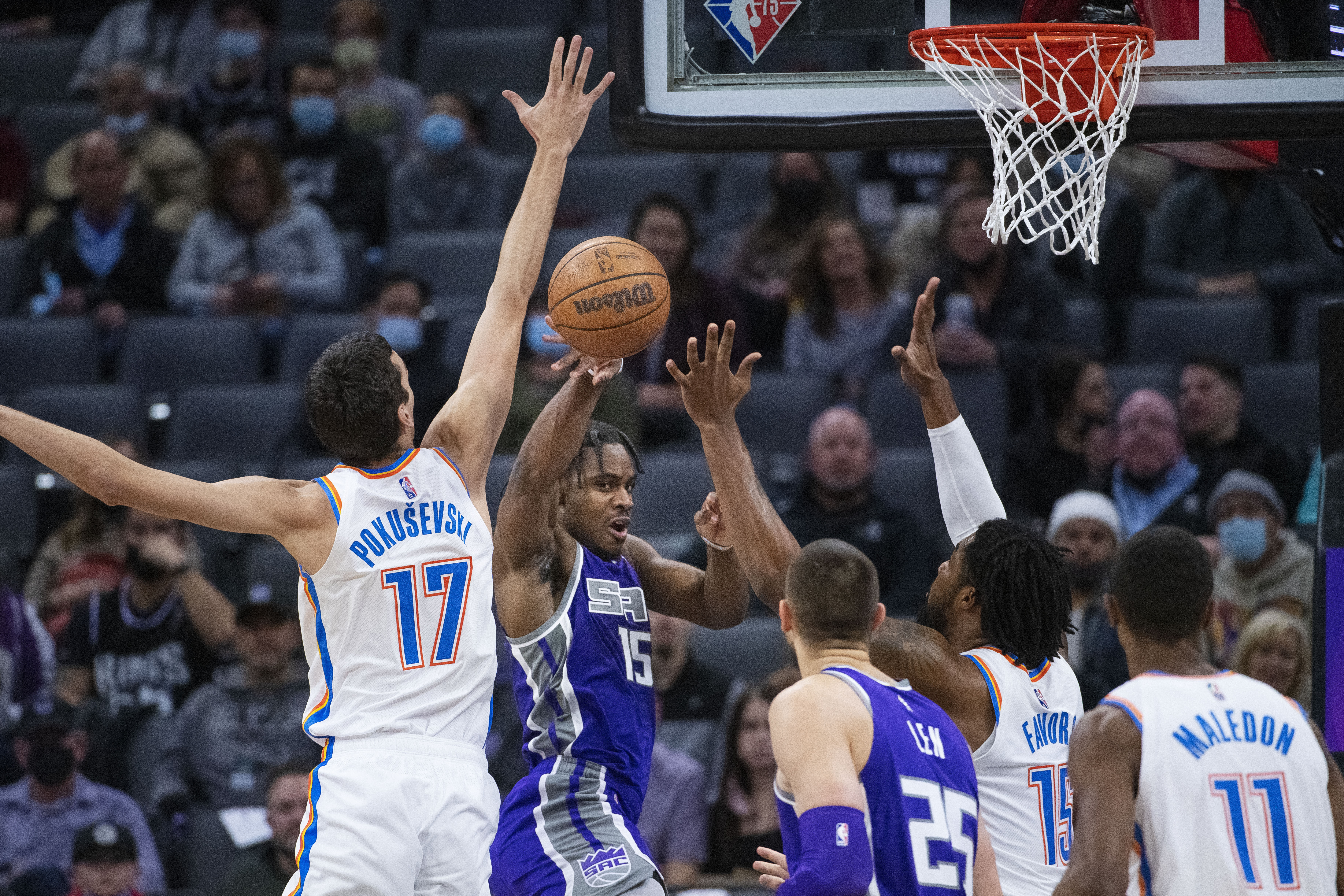 Sacramento Kings guard Davion Mitchell (15) passes the ball past Oklahoma City Thunder center Aleksej Pokusevski (17) during the first quarter of an NBA basketball game in Sacramento, Calif., Saturday, Feb. 5, 2022. (AP Photo/Randall Benton)