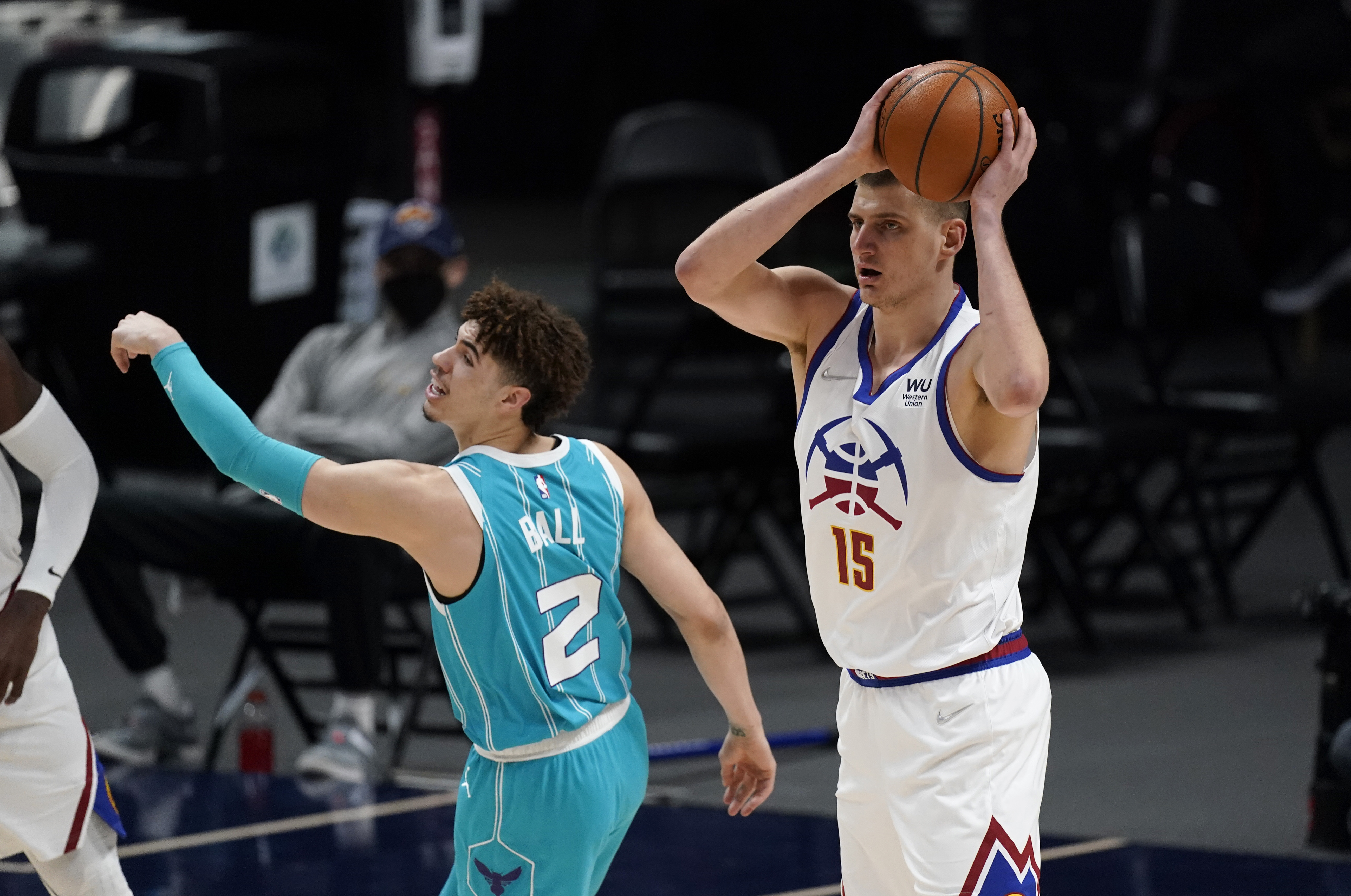 Denver Nuggets center Nikola Jokic, right, pulls in a rebound as Charlotte Hornets guard LaMelo Ball defends in the first half of an NBA basketball game Wednesday, March 17, 2021, in Denver. (AP Photo/David Zalubowski)