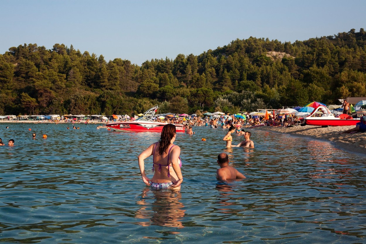 Swimmers on the beach in front of Camping Armenistis, Chalkidiki, Thessaloniki, Greece.